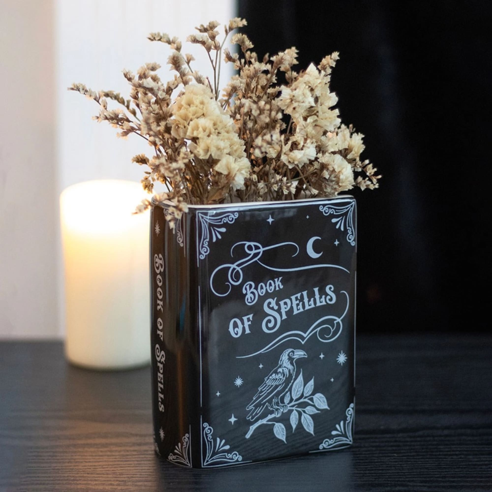 Dried flowers arranged in a black book-shaped vase