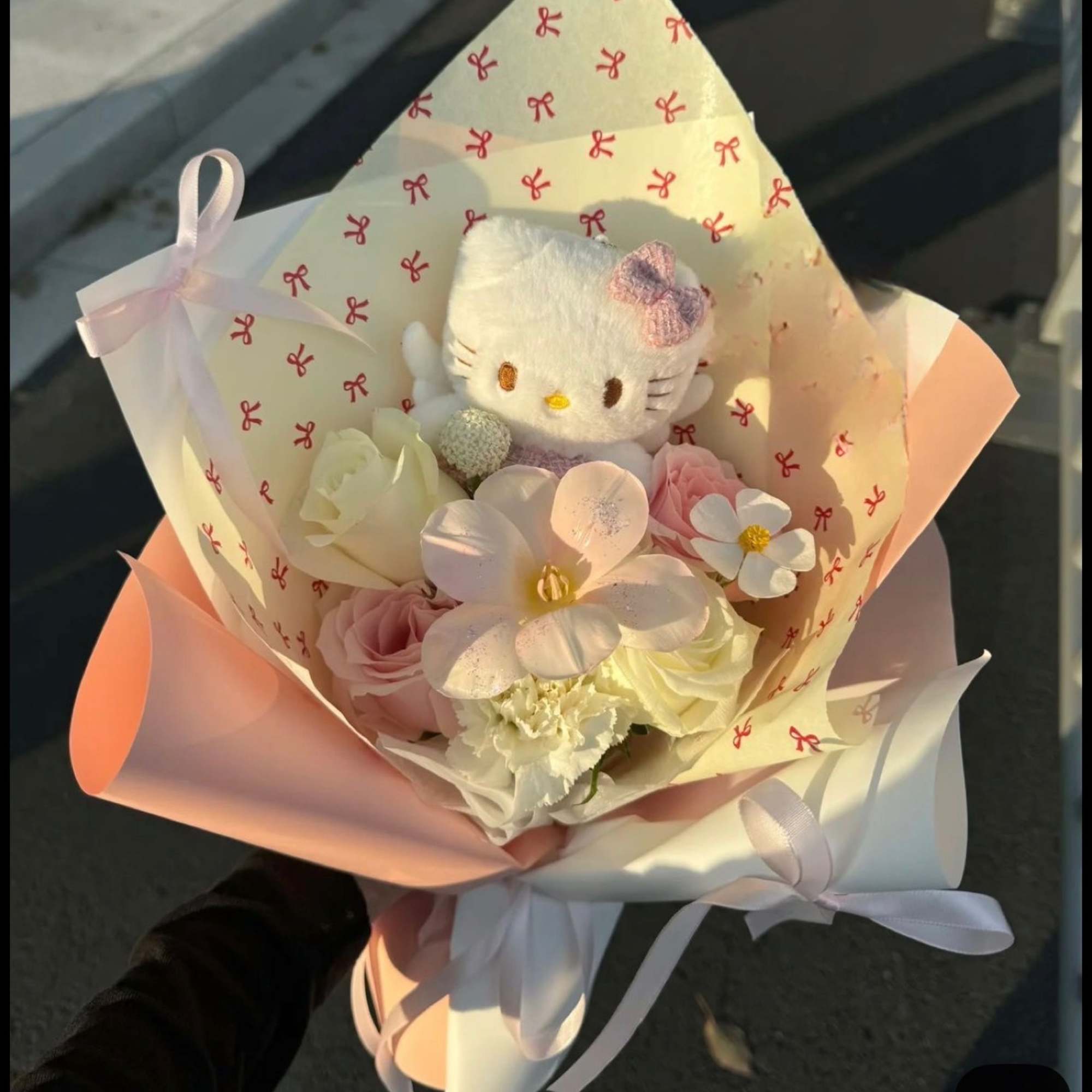 Pastel bouquet with a Hello Kitty plush and pale flowers wrapped in pink paper
