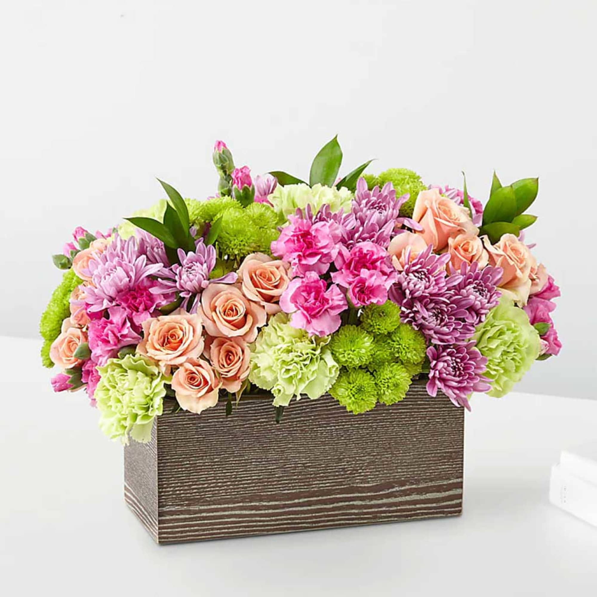 Mixed pink and peach flowers in a rectangular wooden box, photo 2 of 3