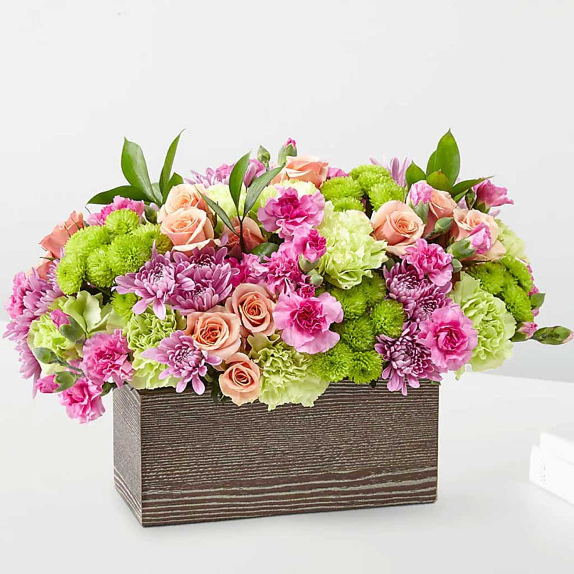 Pink and green mixed flower arrangement in a rectangular wooden box