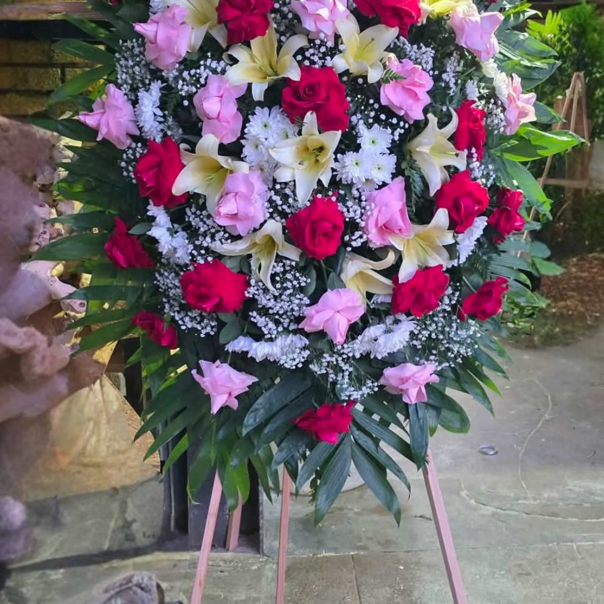 Funeral arrangement with red and pink roses and lilis  . Perfect