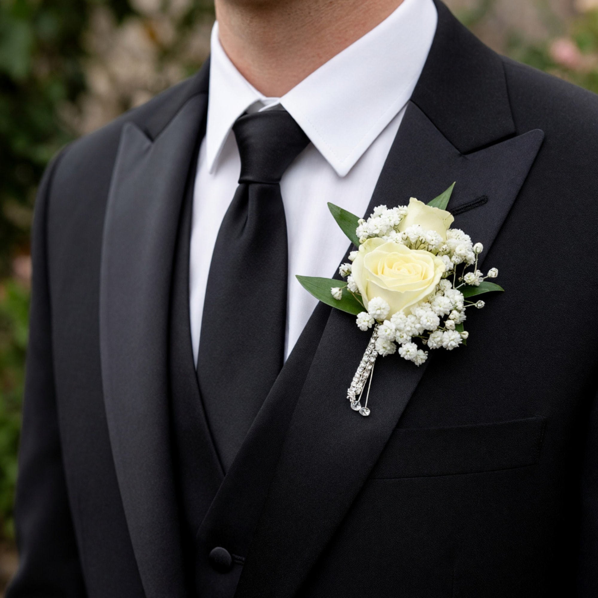 White rose boutonniere on a black suit jacket