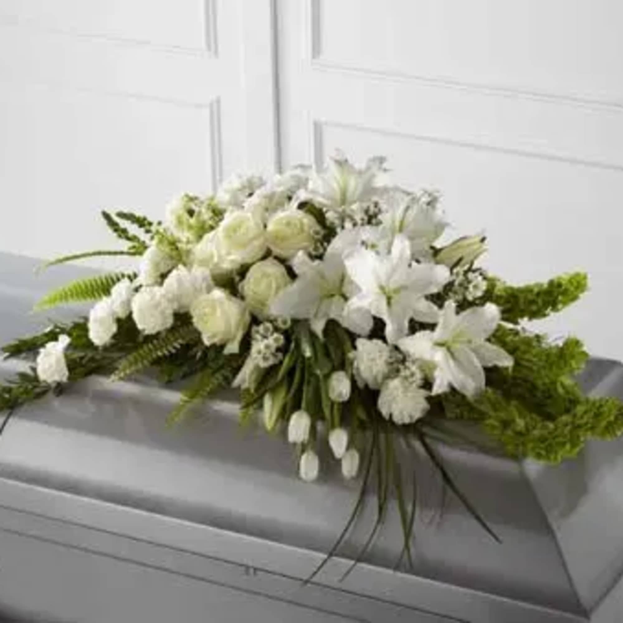 White floral casket spray with lilies and roses