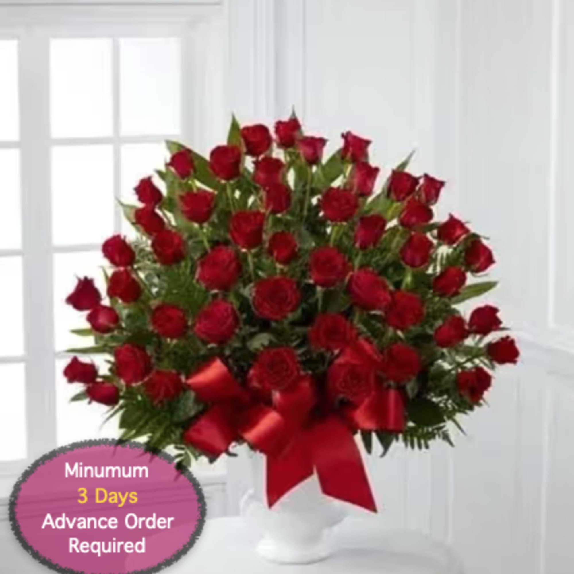 Red rose bouquet with a red ribbon in a white vase