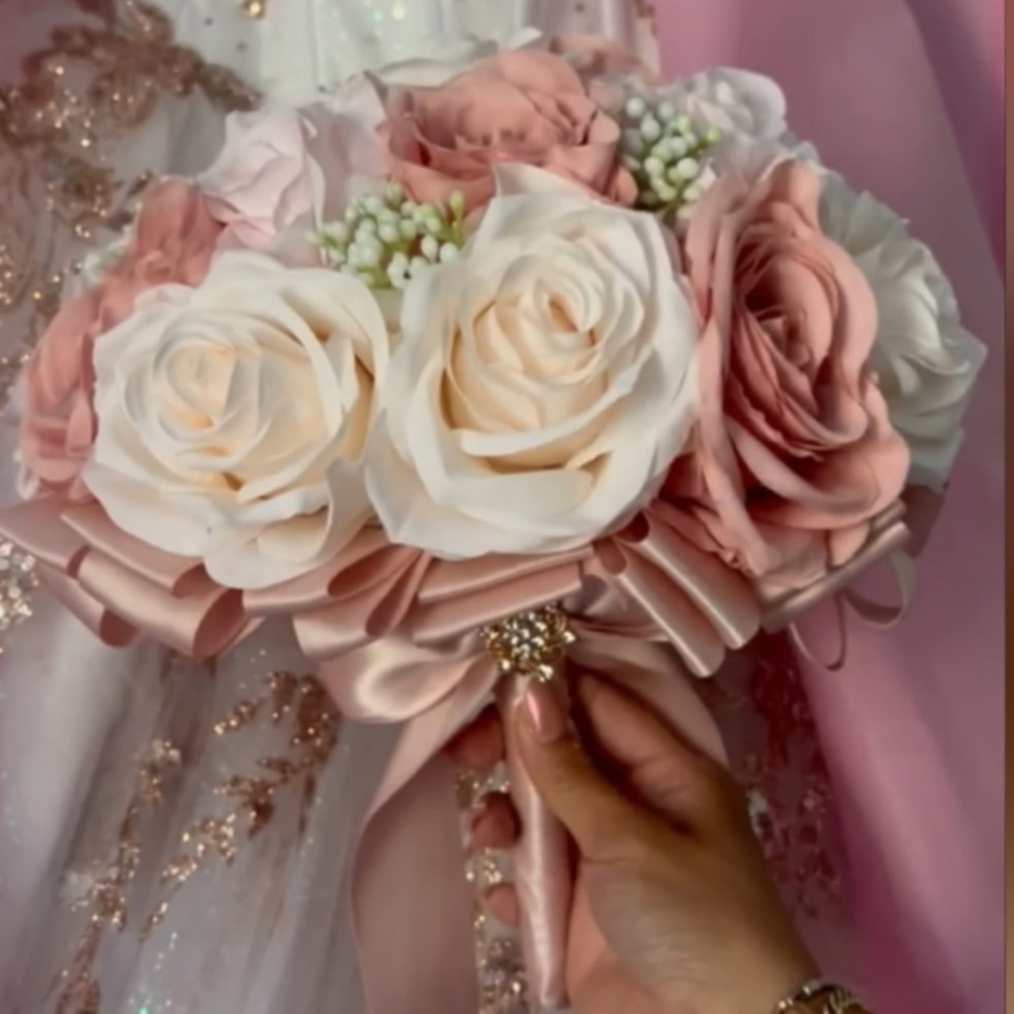 Handheld bouquet of blush and ivory roses with satin ribbon