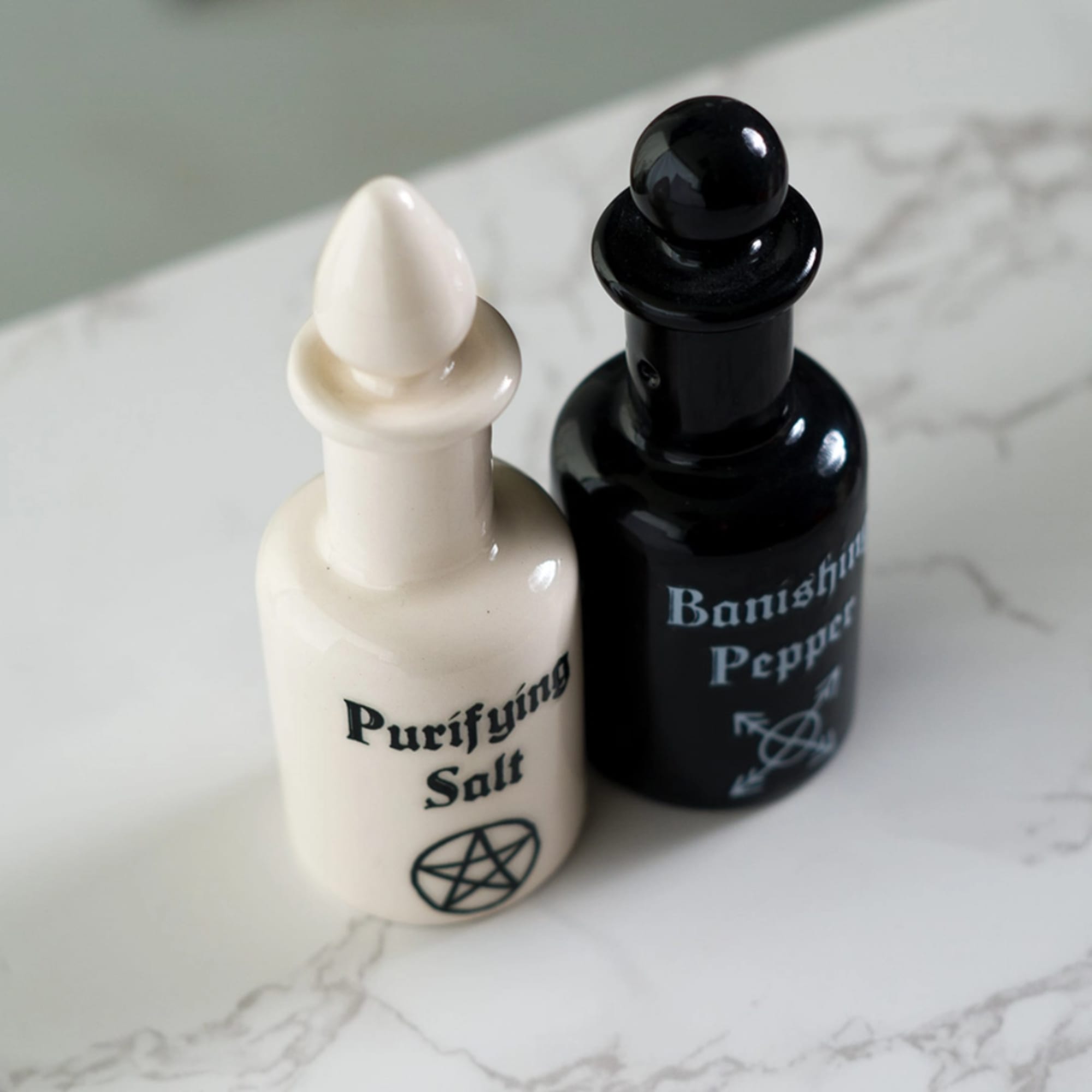Two small labeled bottles on a marble surface