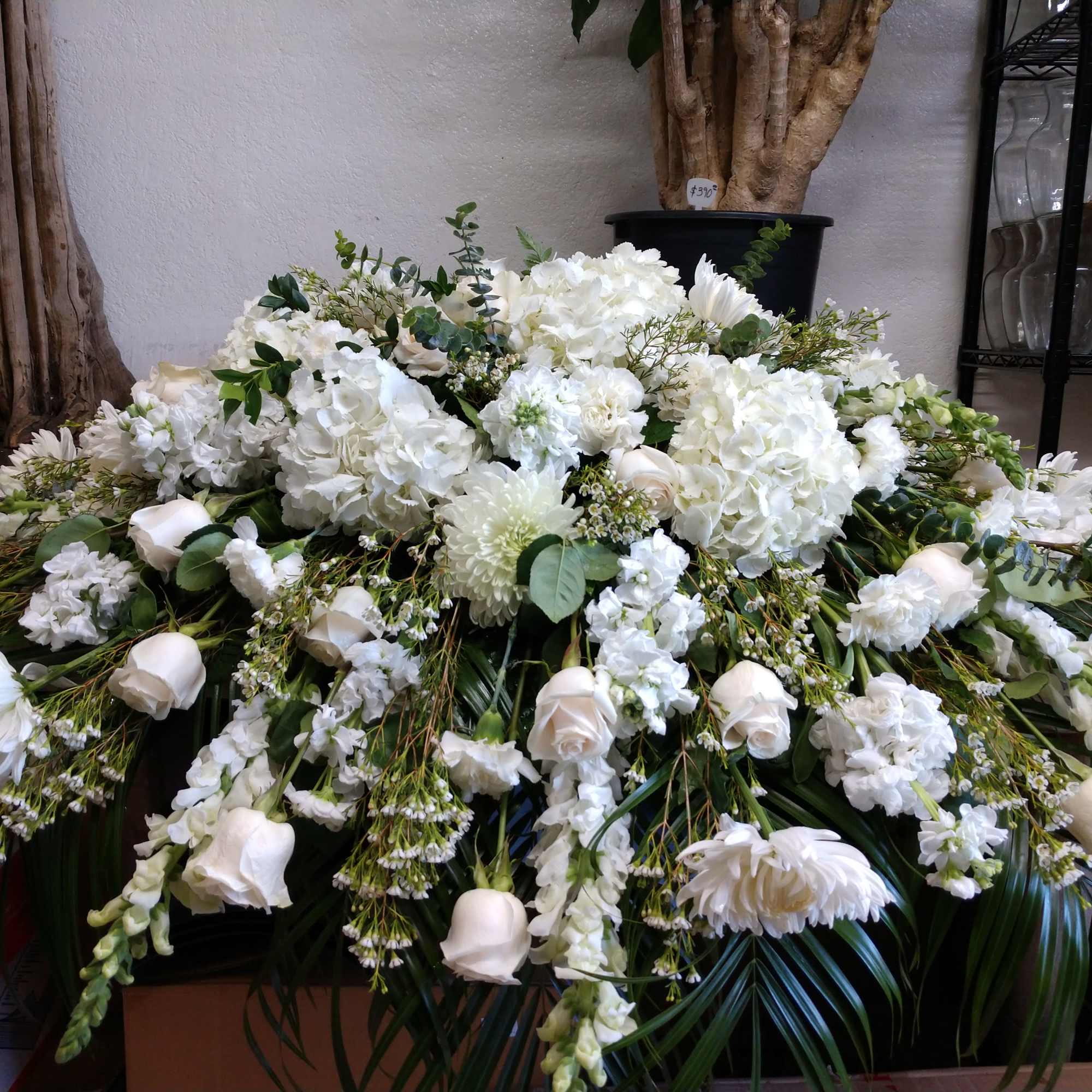 Large white funeral spray with roses, hydrangeas, and chrysanthemums