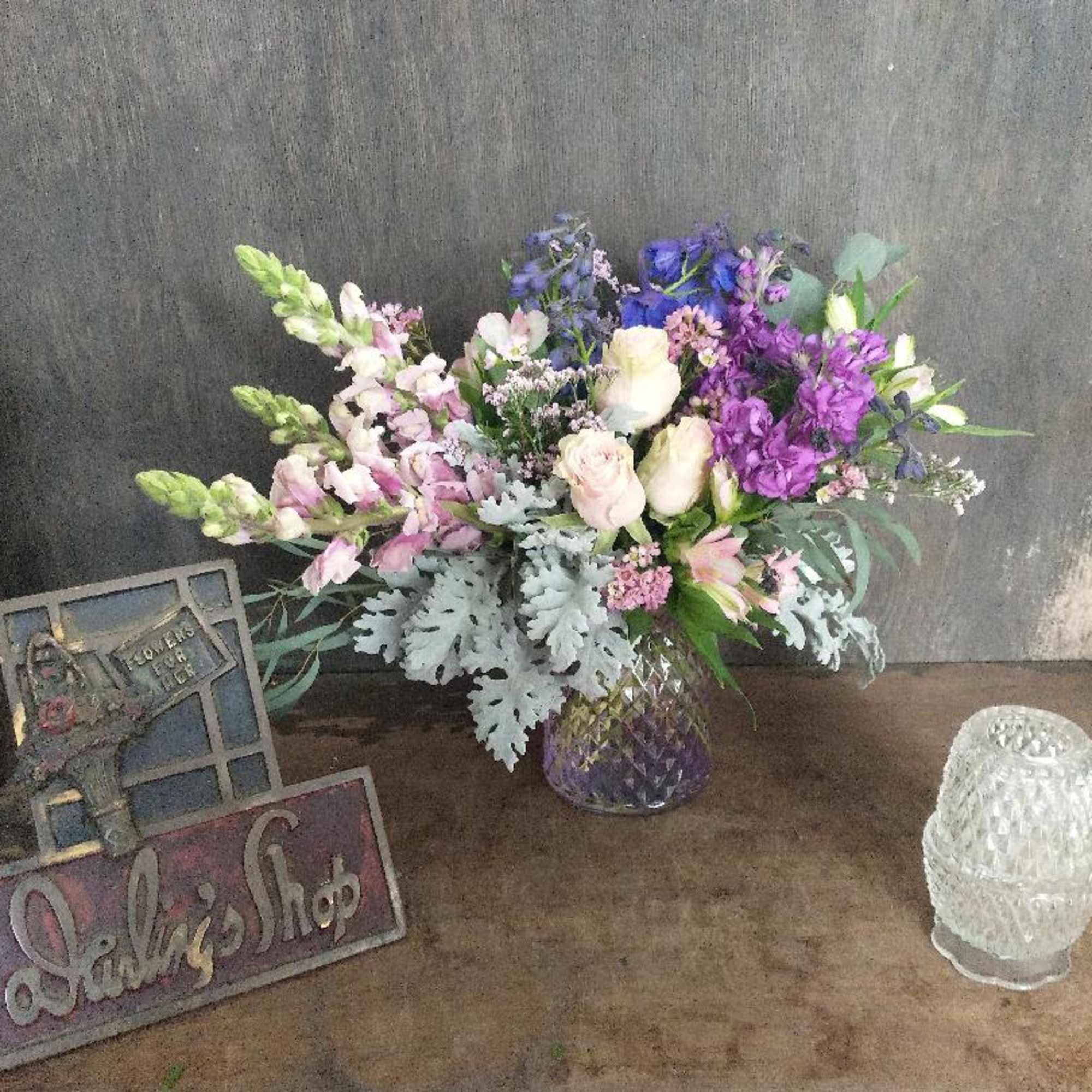Mixed bouquet of purple, pink, and white flowers in a glass vase