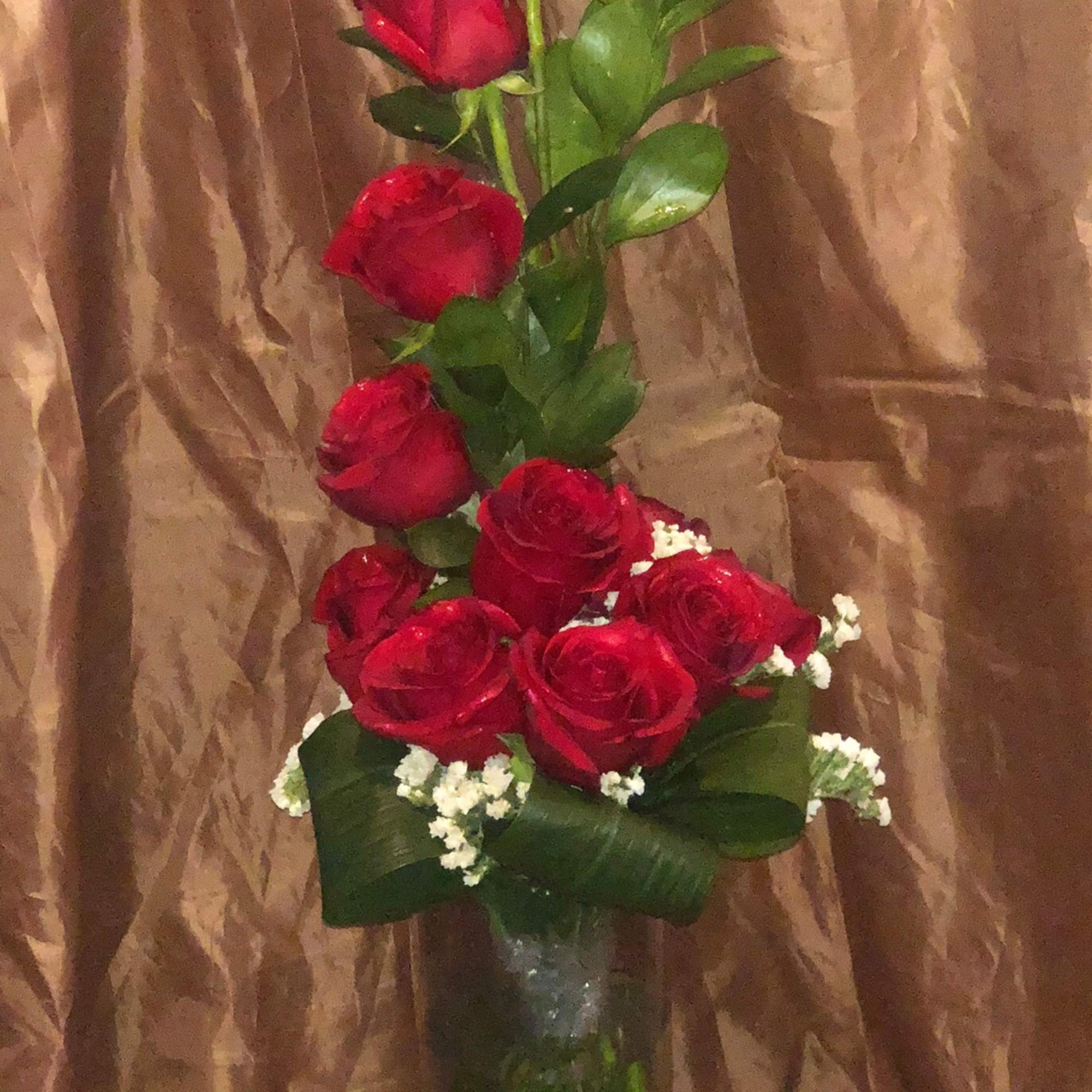 Tall bouquet of red roses in a clear glass vase
