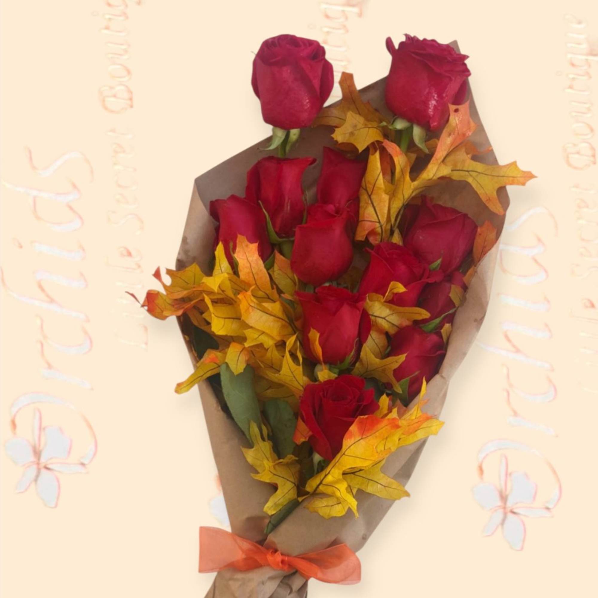 Bouquet of red roses wrapped in brown paper with autumn leaves