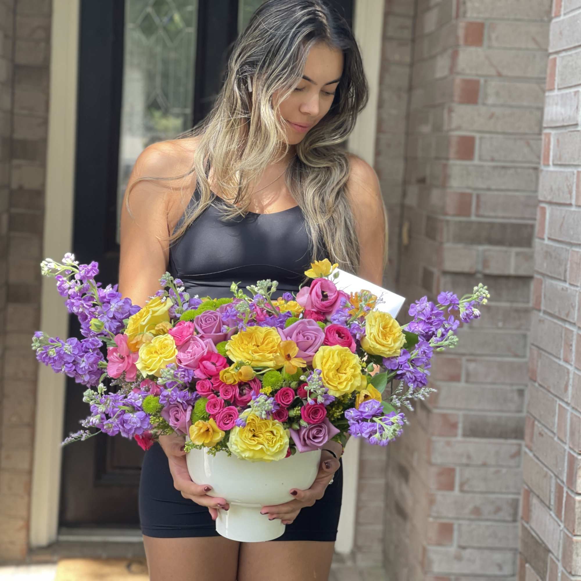 Woman holding a large bouquet in a white vase