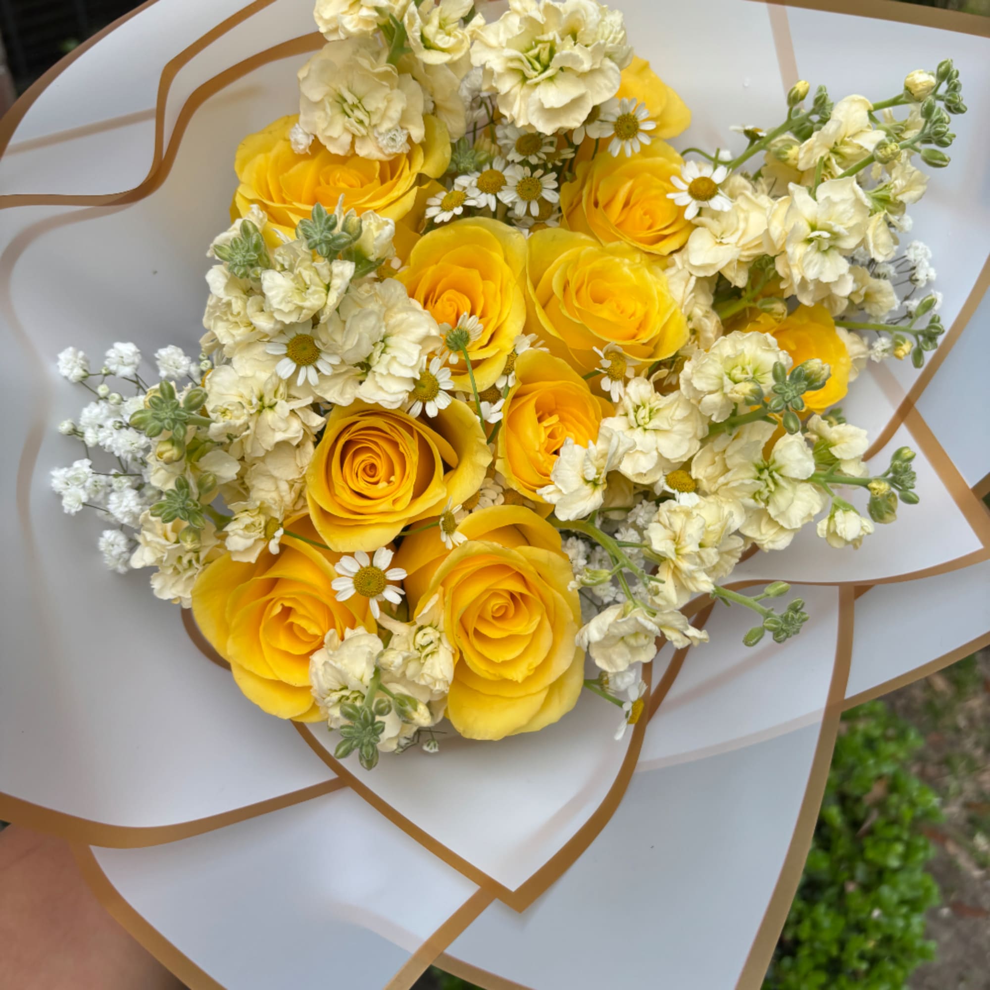 Yellow roses and white flowers in white wrap with gold trim