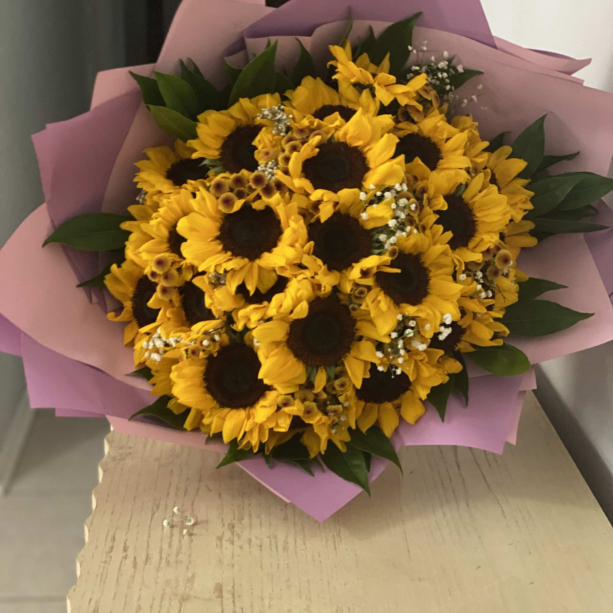 Bouquet of yellow sunflowers wrapped in pink paper