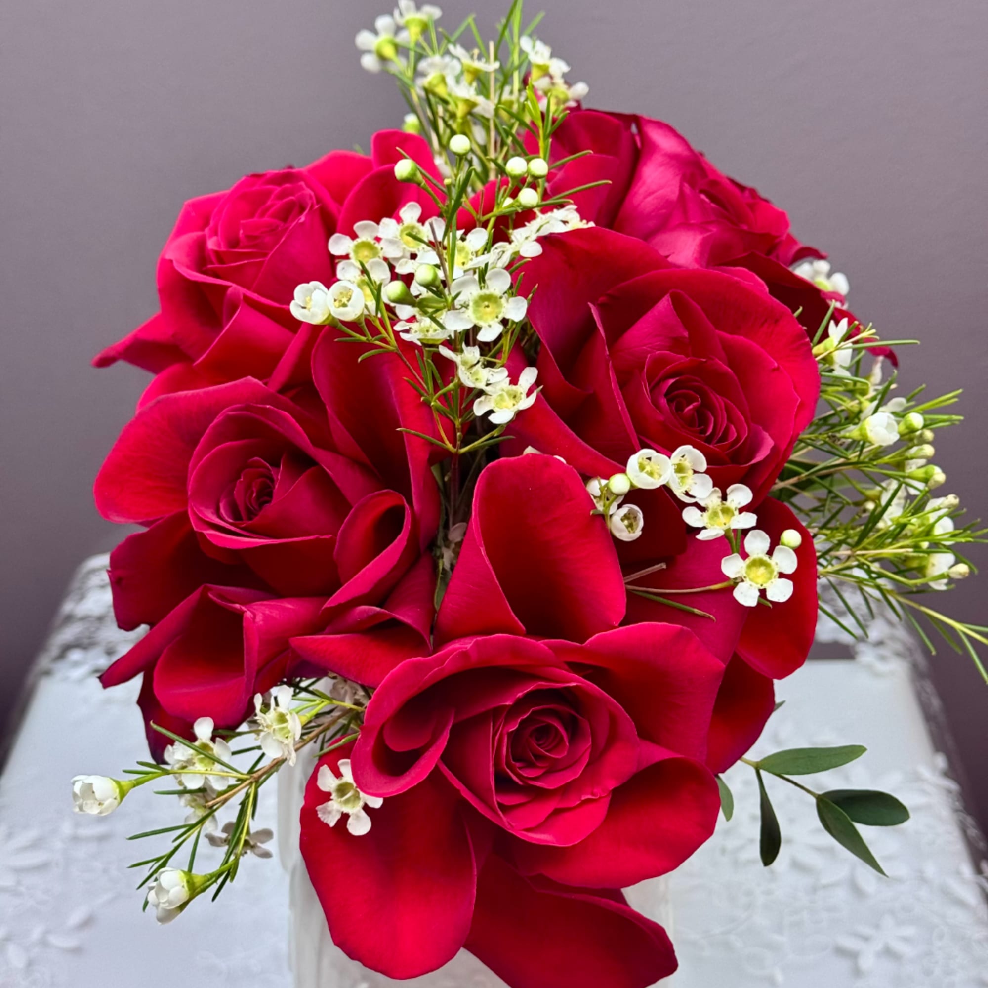 Bouquet of red roses with small white filler flowers