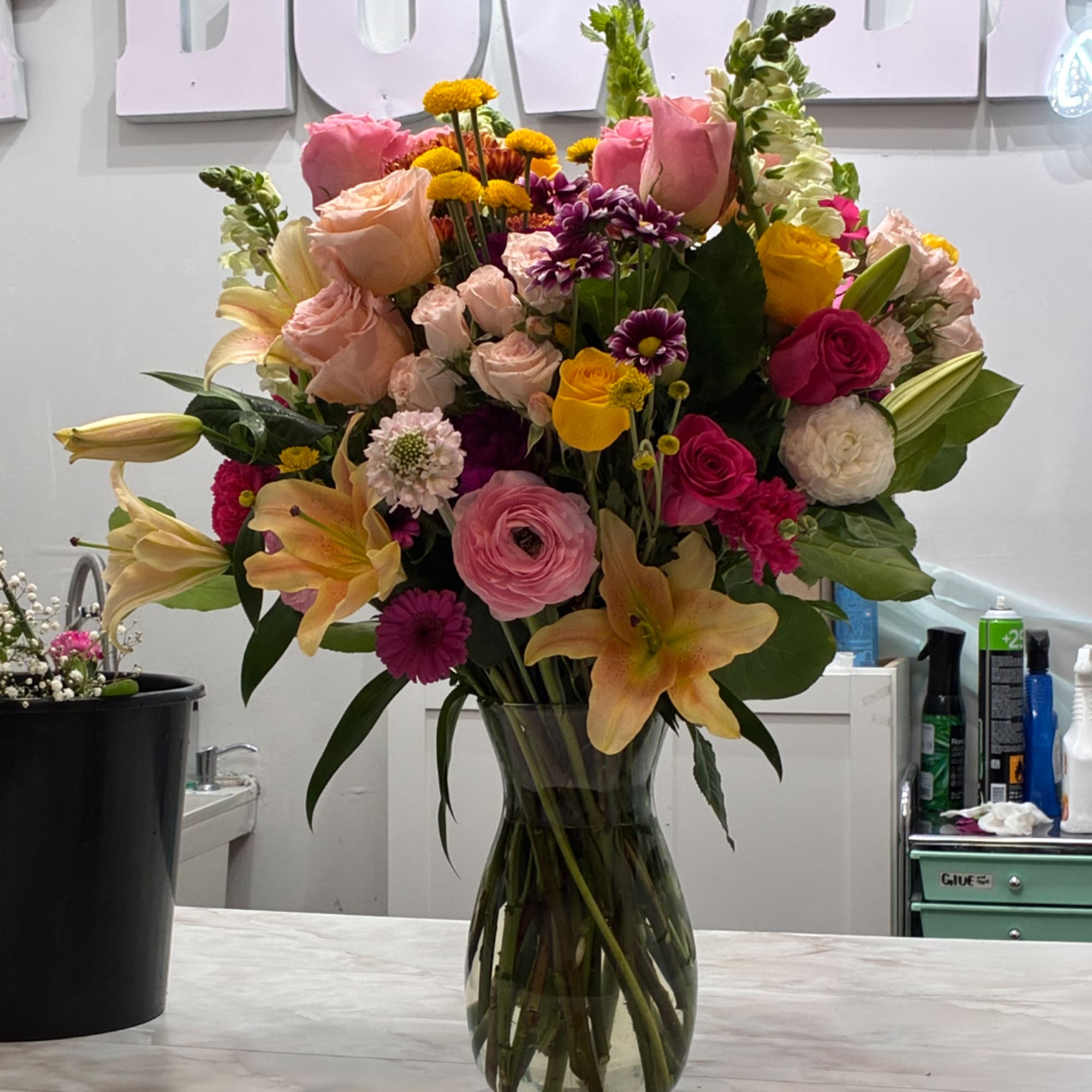Mixed bouquet of pink, yellow, and white flowers in a glass vase
