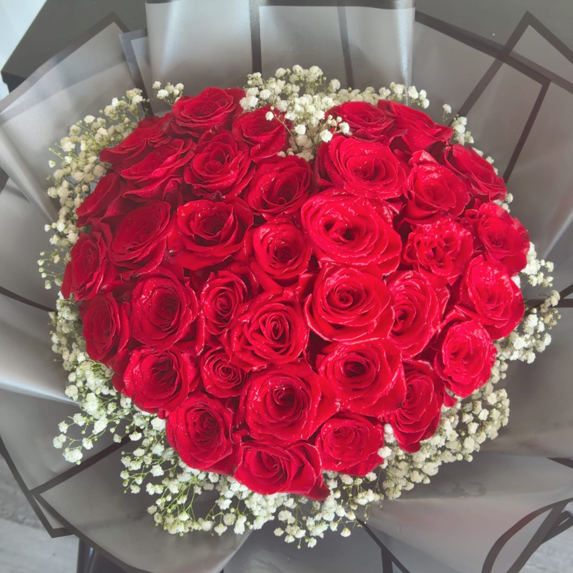 Bouquet of red roses with white baby's breath in gray wrap, photo 2 of 5