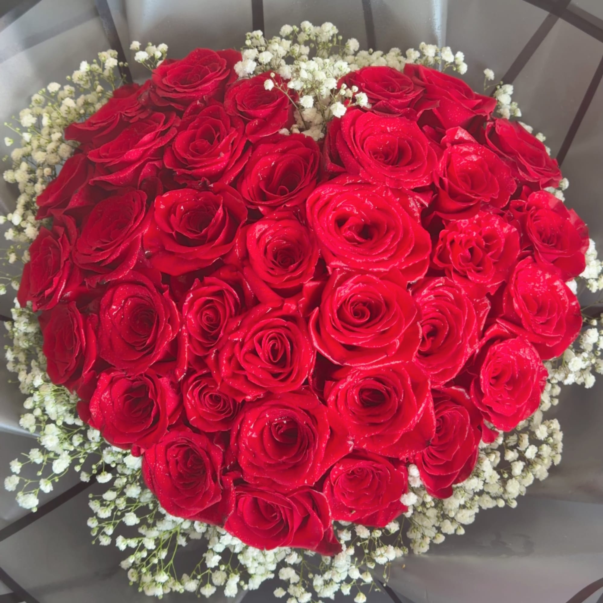 Round bouquet of red roses with white baby's breath