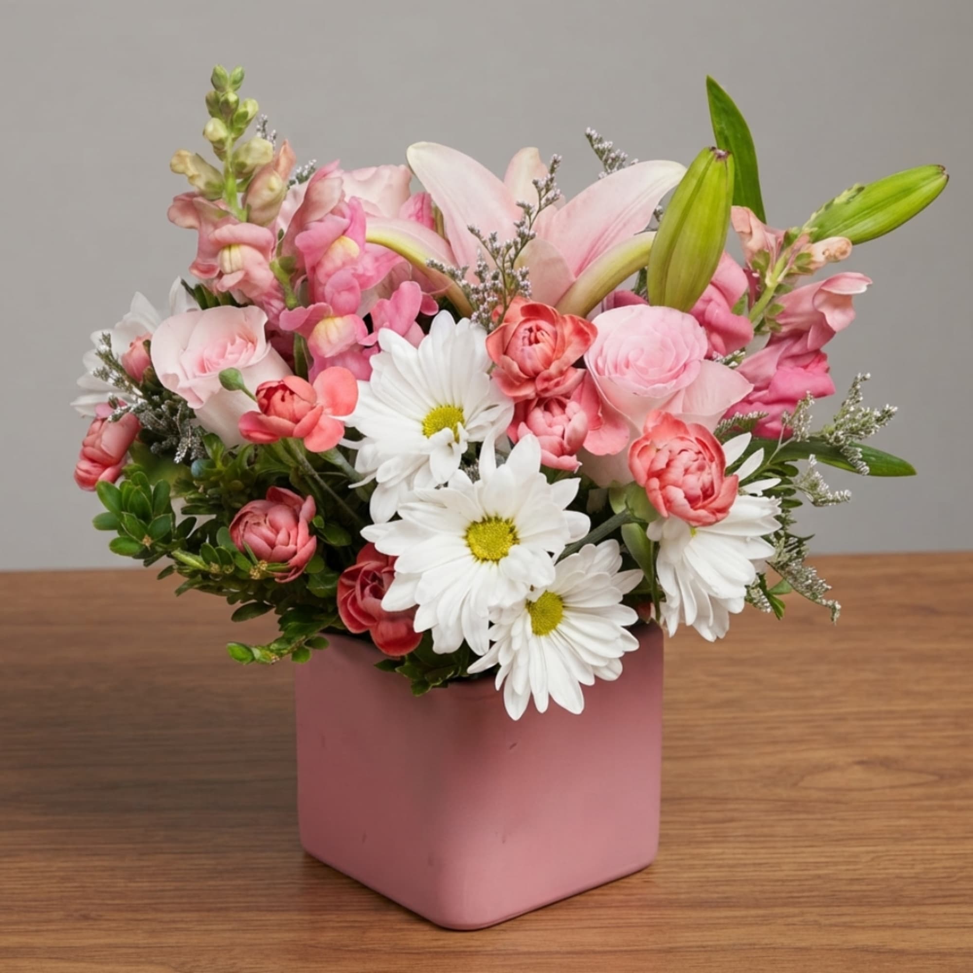Pink and white mixed bouquet in a pink square vase