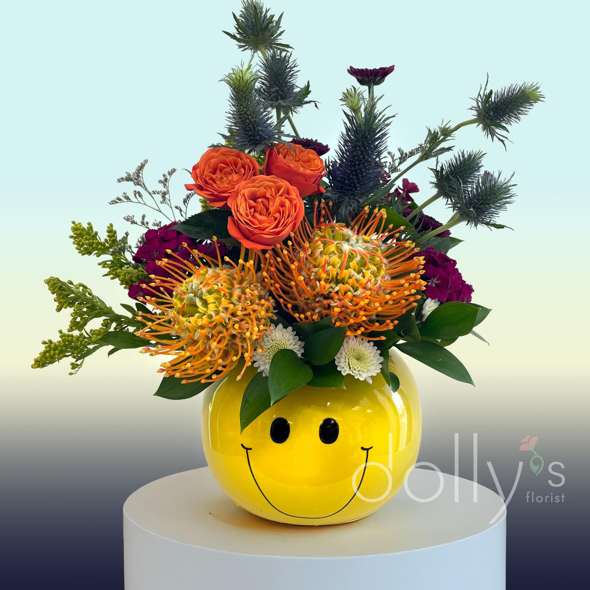 Bright mixed bouquet in a yellow smiley-face vase