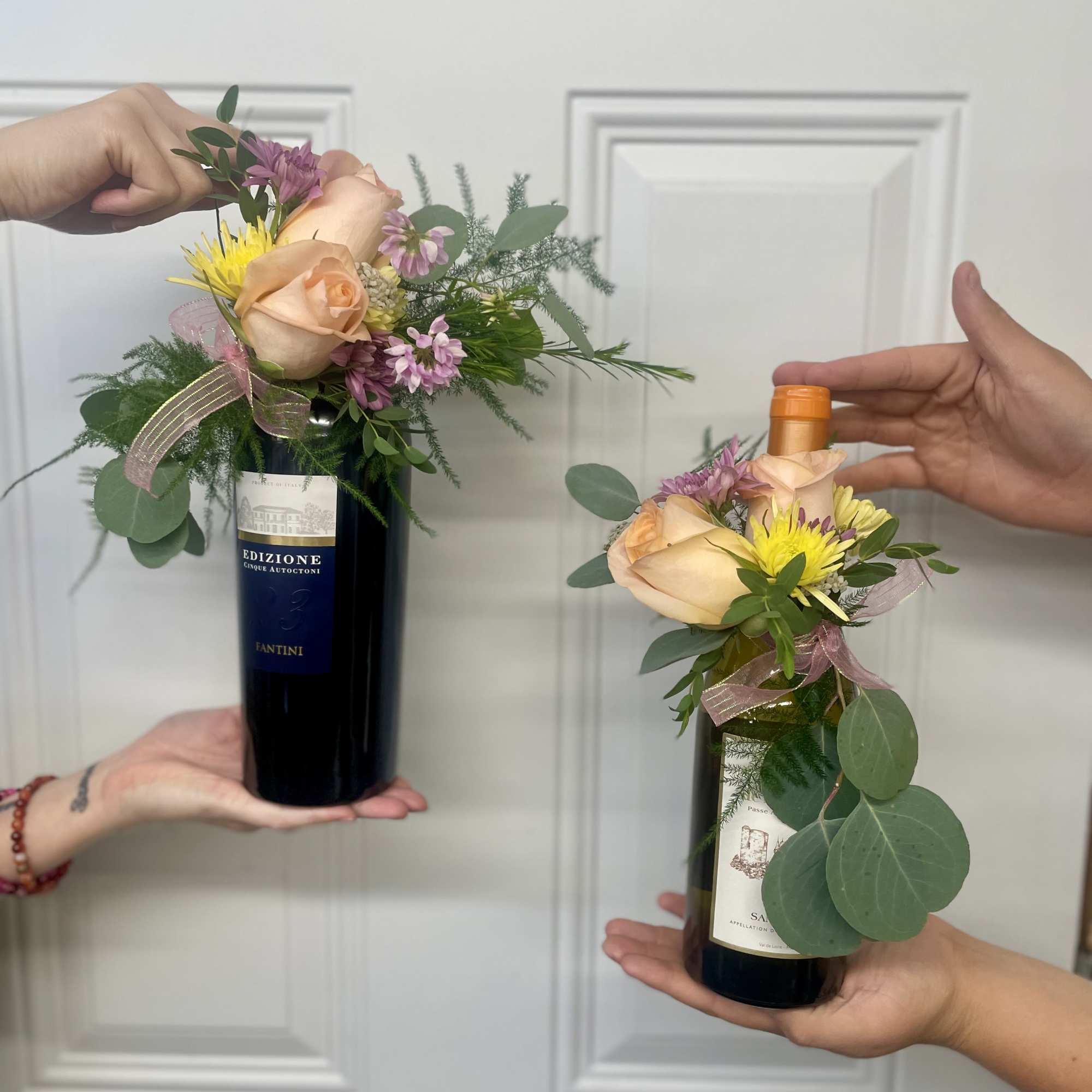 Wine bottles topped with small floral arrangements
