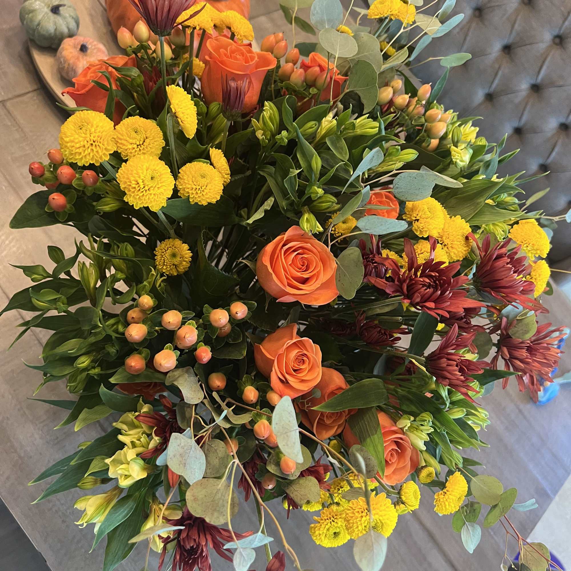 Bouquet of orange roses, yellow mums, and burgundy flowers