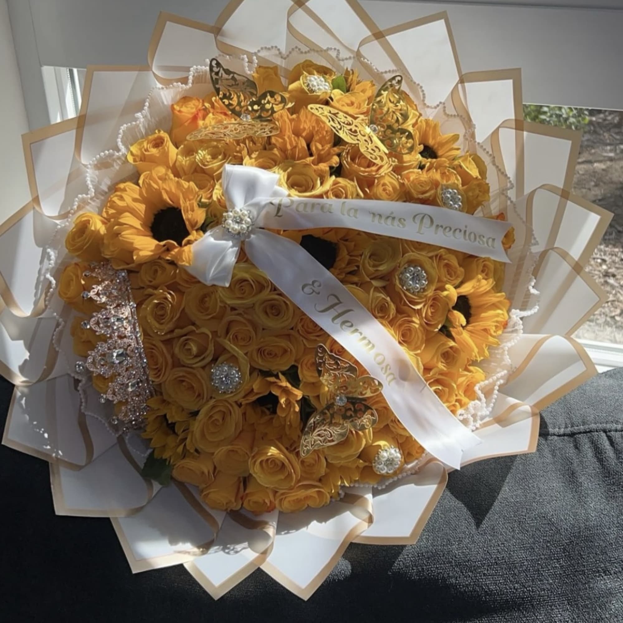 Bouquet of yellow roses and sunflowers with a white ribbon
