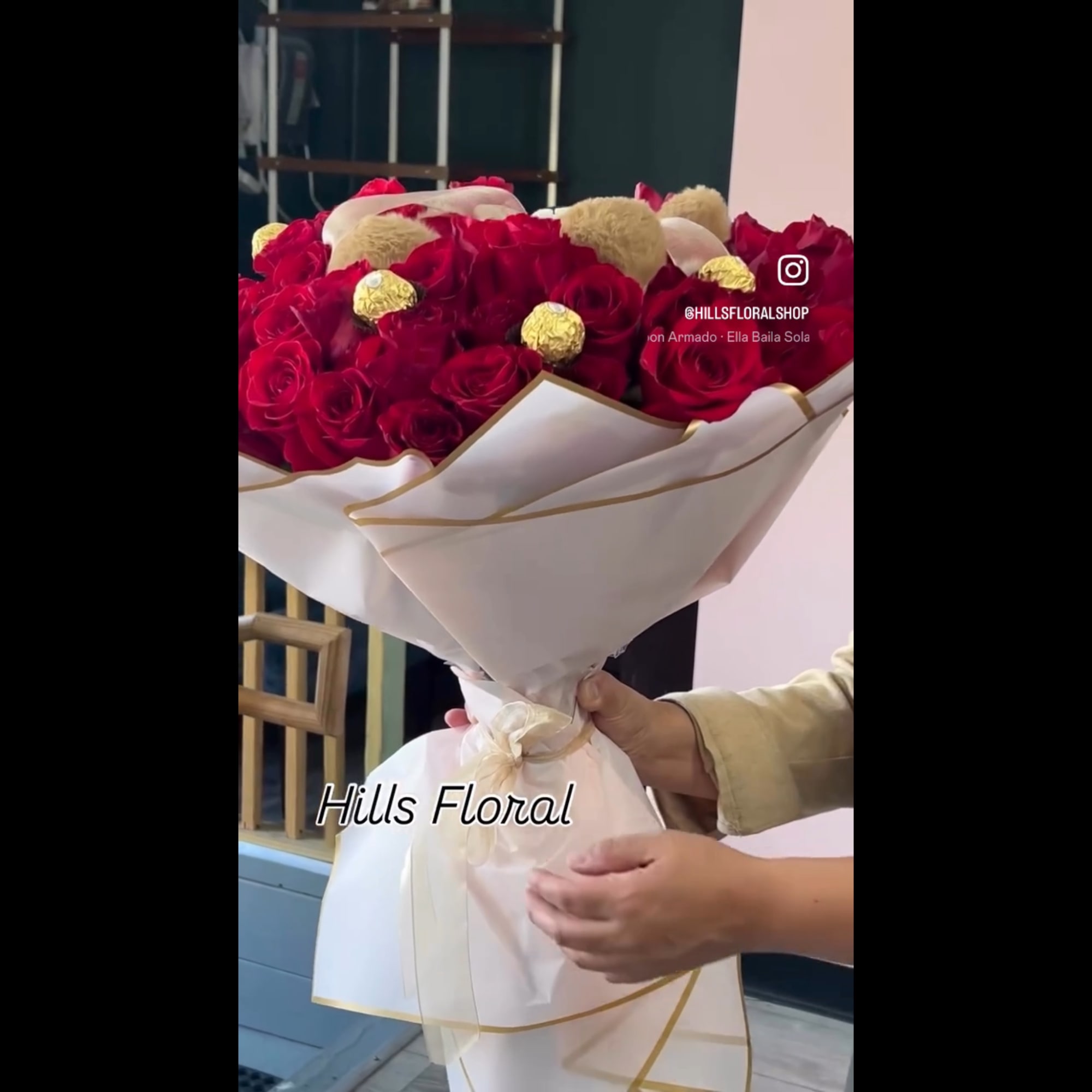 Large bouquet of red roses wrapped in white paper with gold trim