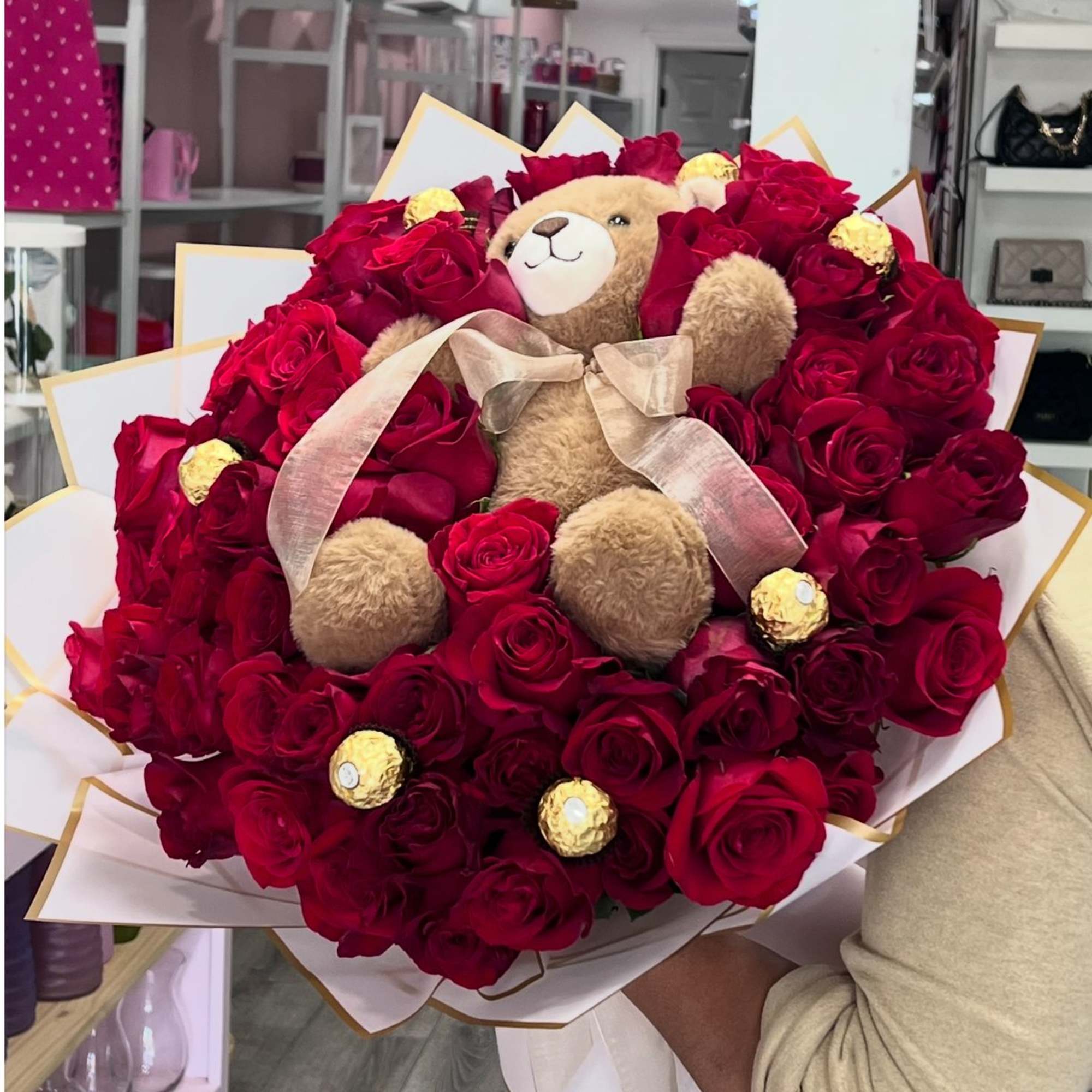 Bouquet of red roses with a teddy bear and gold-wrapped chocolates