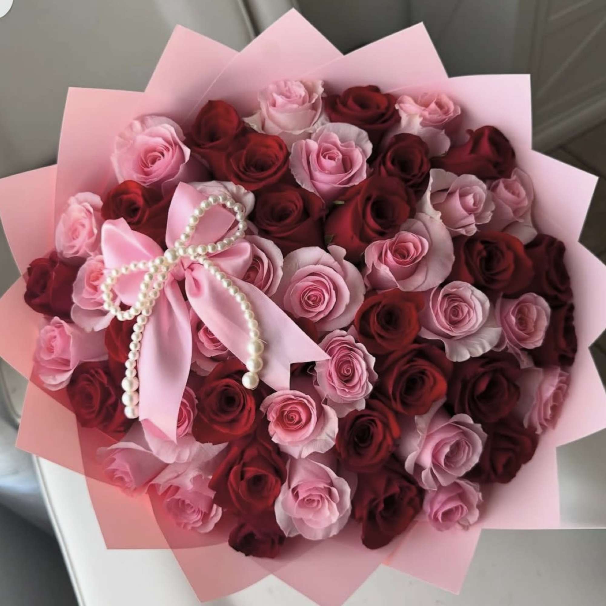 Dense clusters of alternating pink and deep red roses create a lush