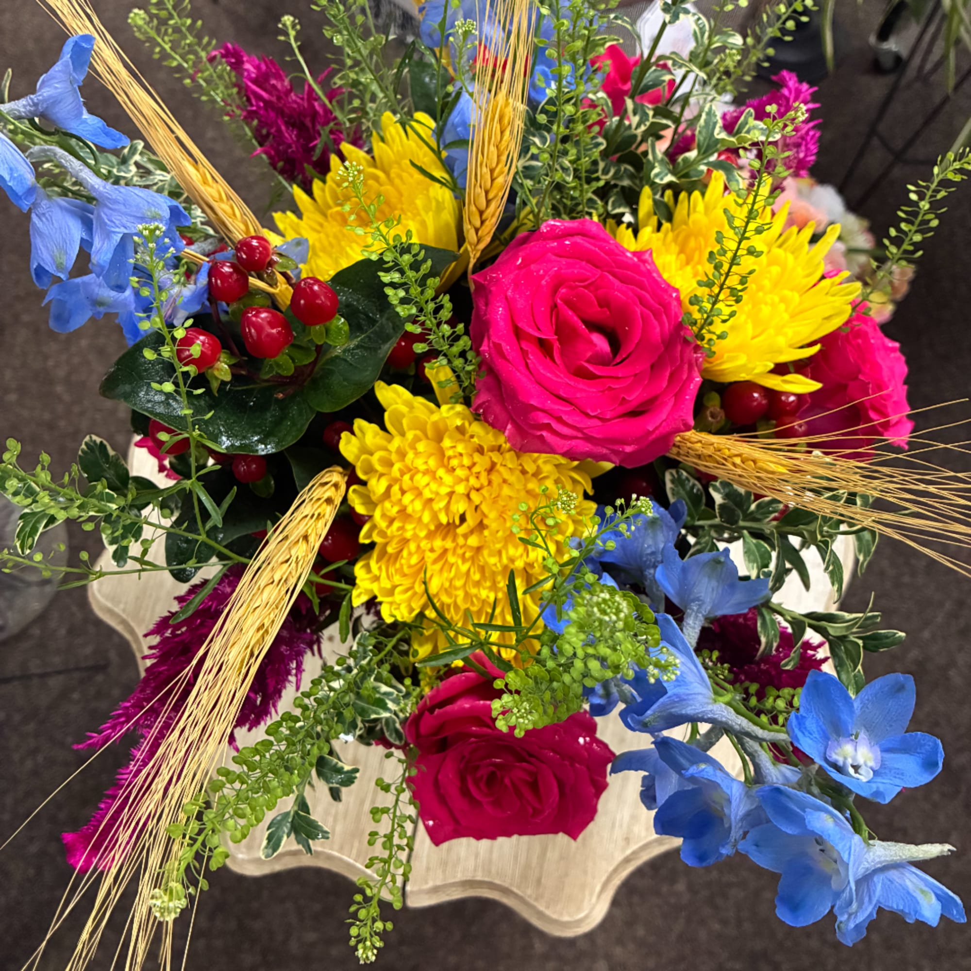 Bright mixed bouquet with pink roses, yellow mums, and blue flowers