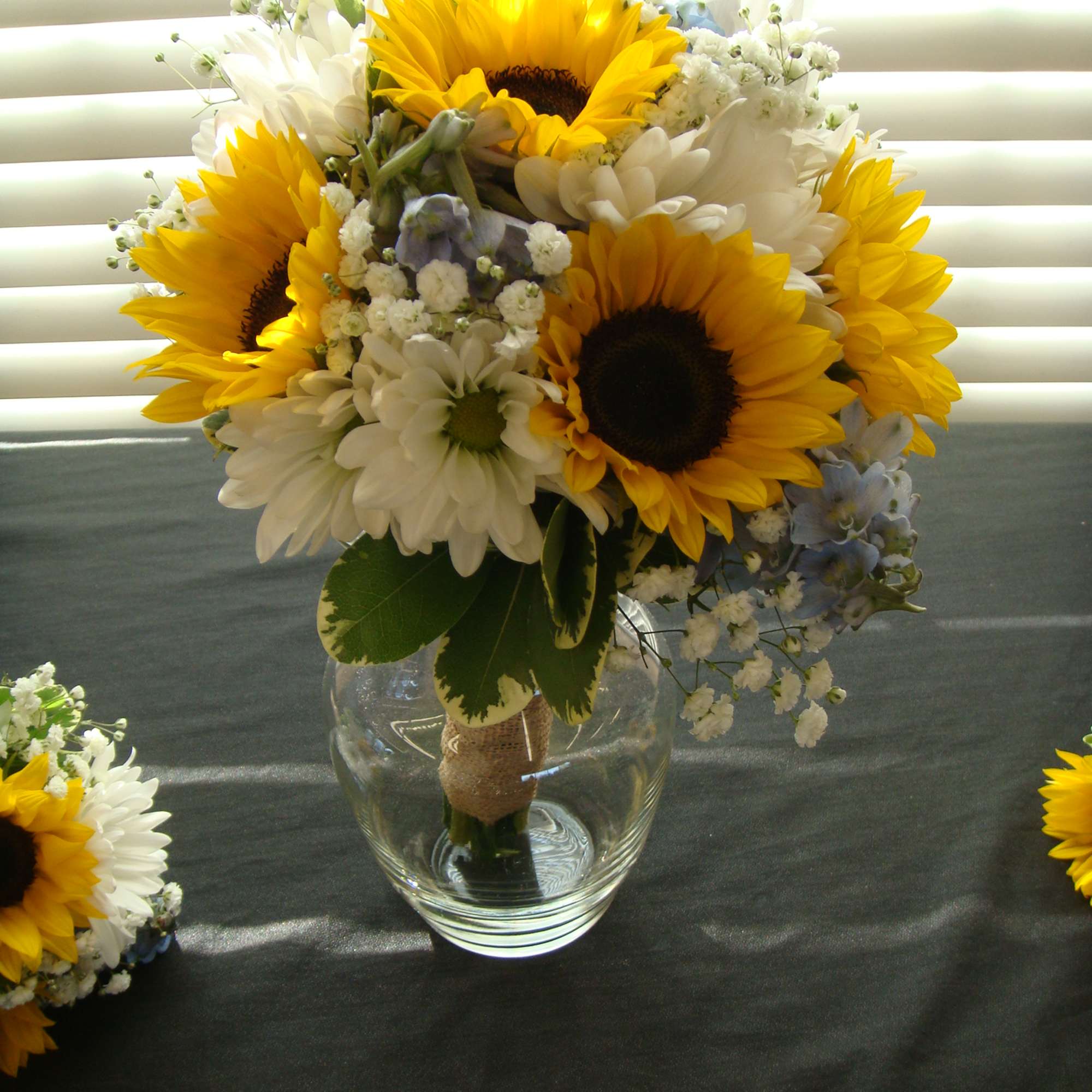 Sunflower and white daisy bouquet in a clear glass vase