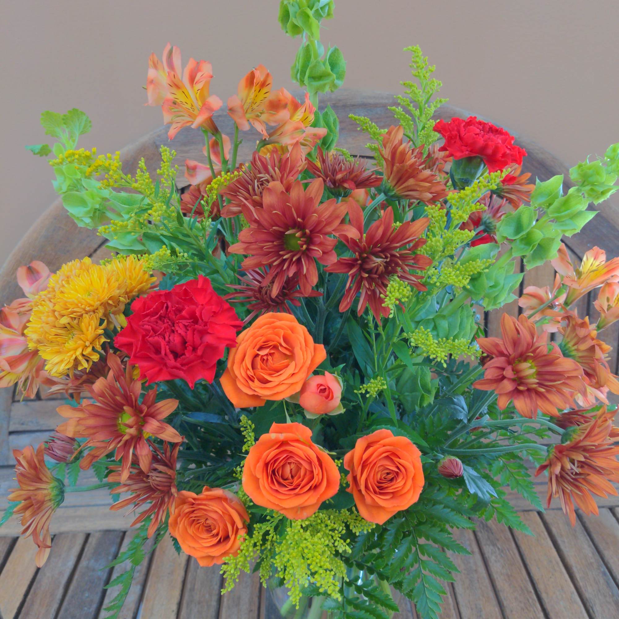 Mixed orange and red bouquet in a glass vase