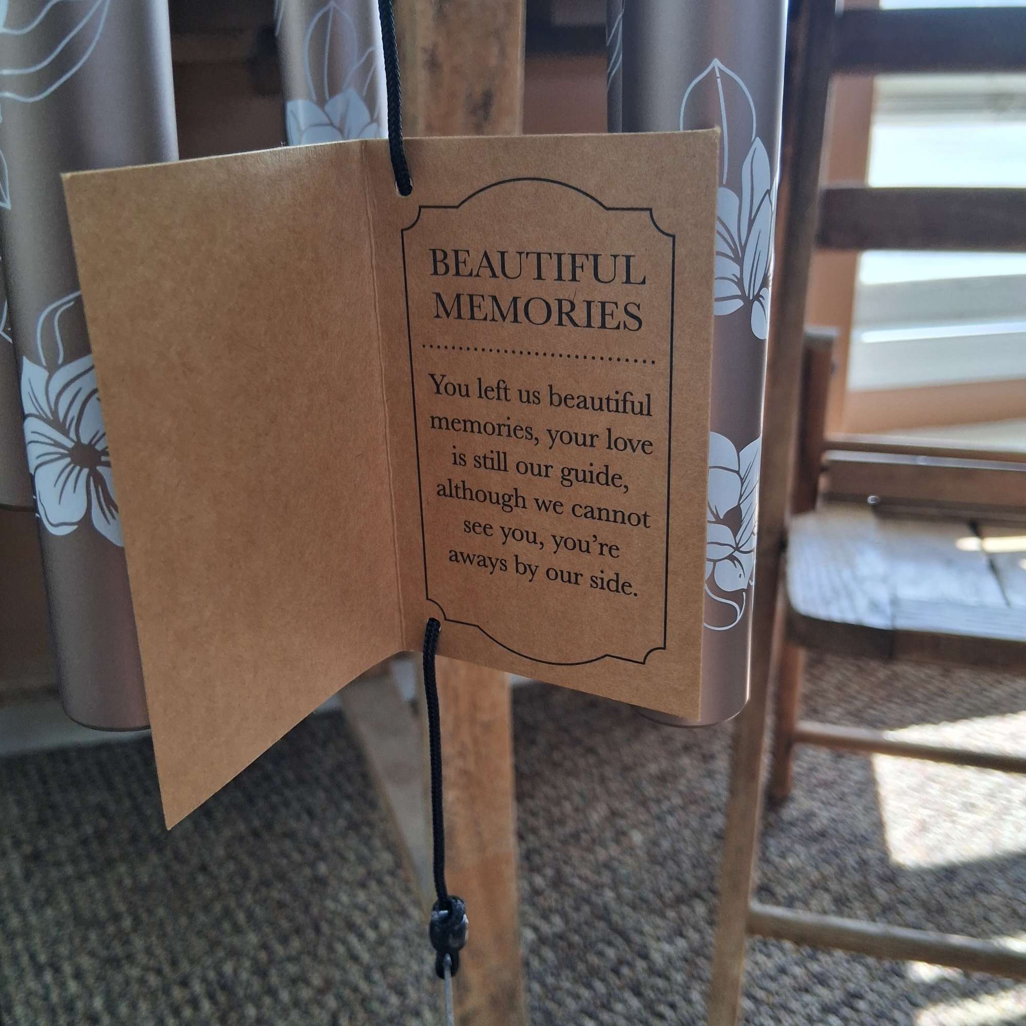 Memorial card hanging from a wind chime with printed text