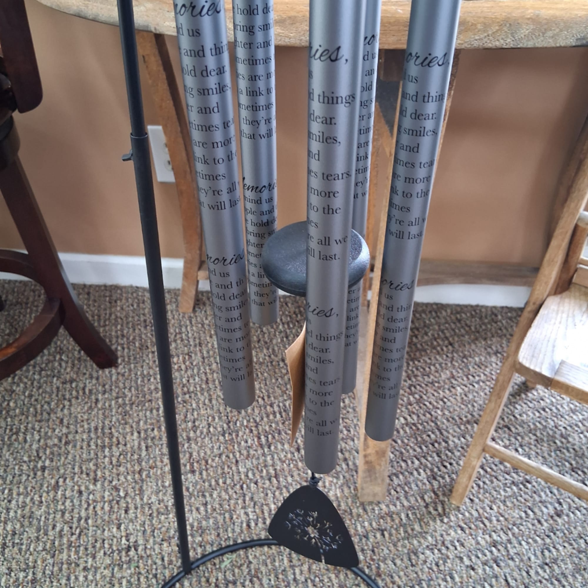 Hanging memorial wind chimes with printed tubes and a black clapper