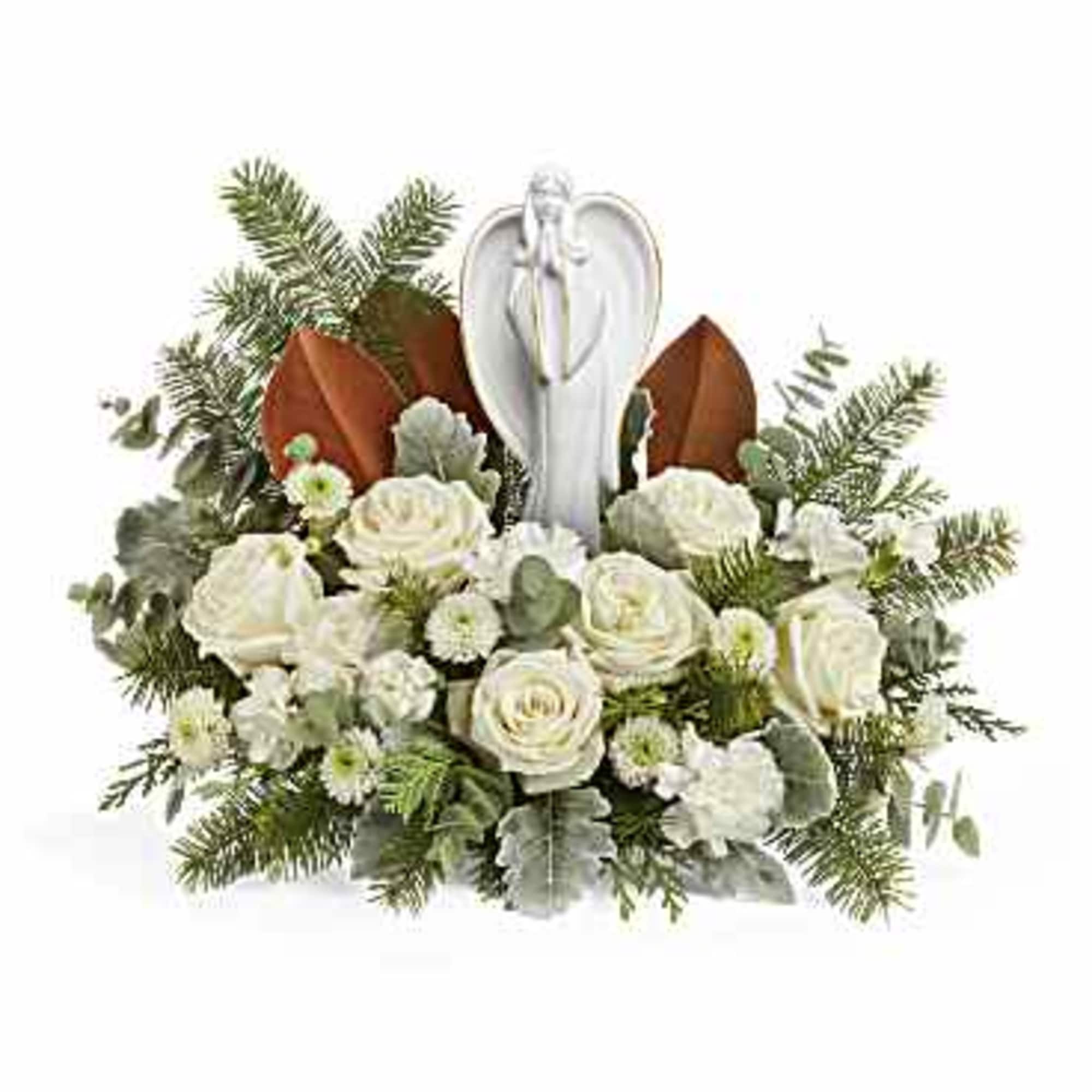 White floral arrangement with an angel figurine and evergreen accents