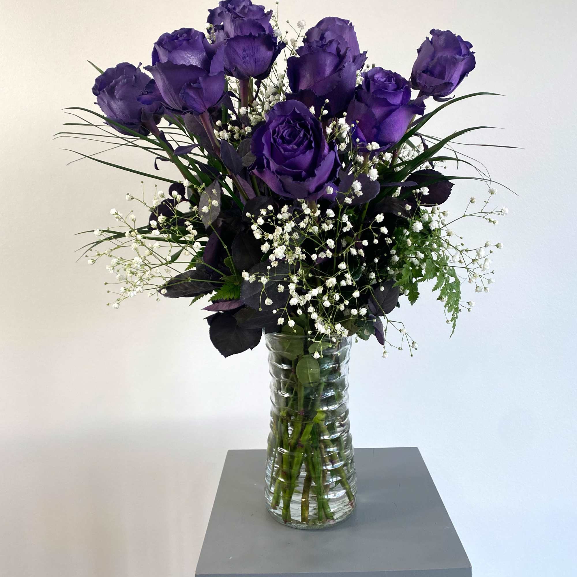 Purple roses in a clear glass vase with white baby's breath, photo 2 of 3