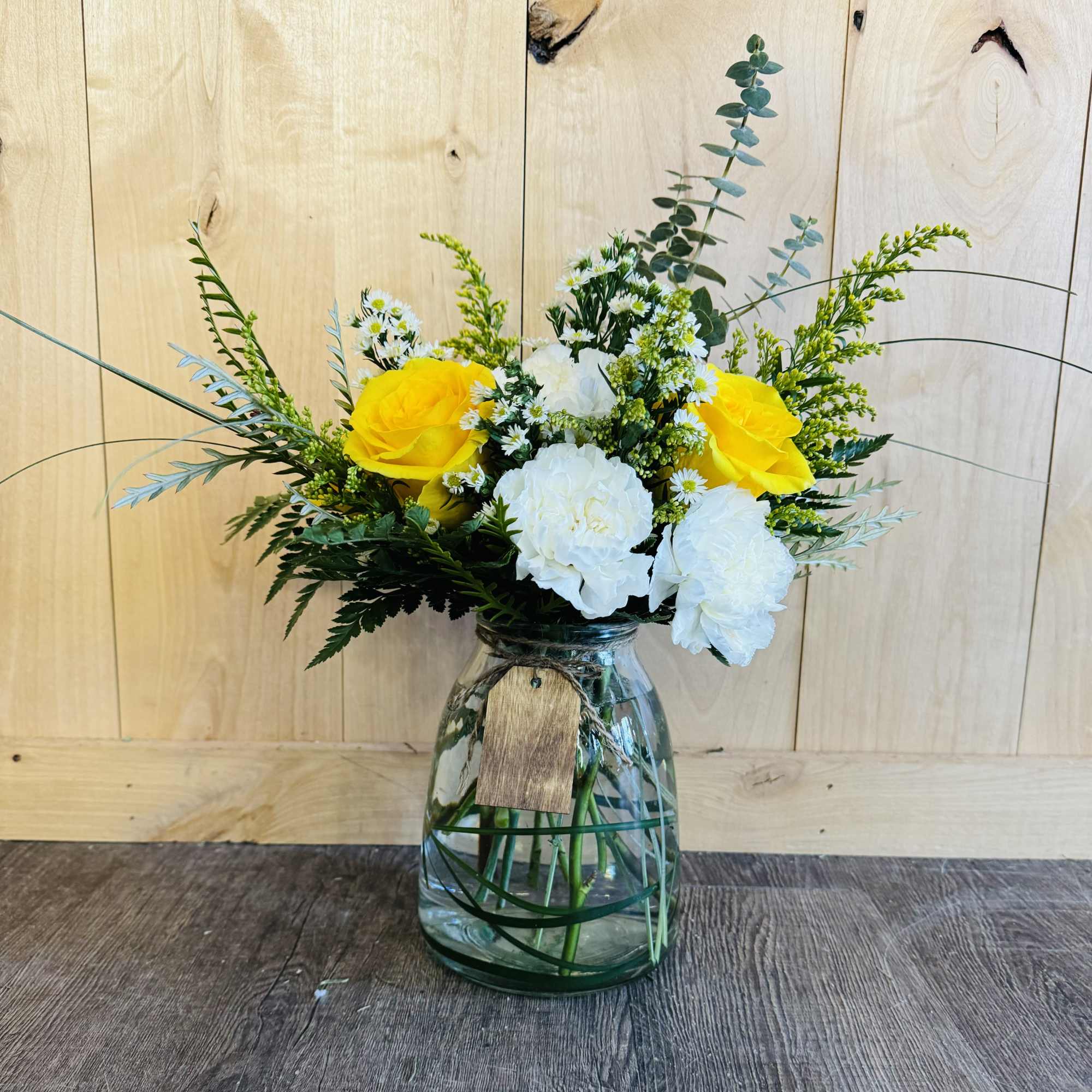 Yellow and white flowers arranged in a glass vase