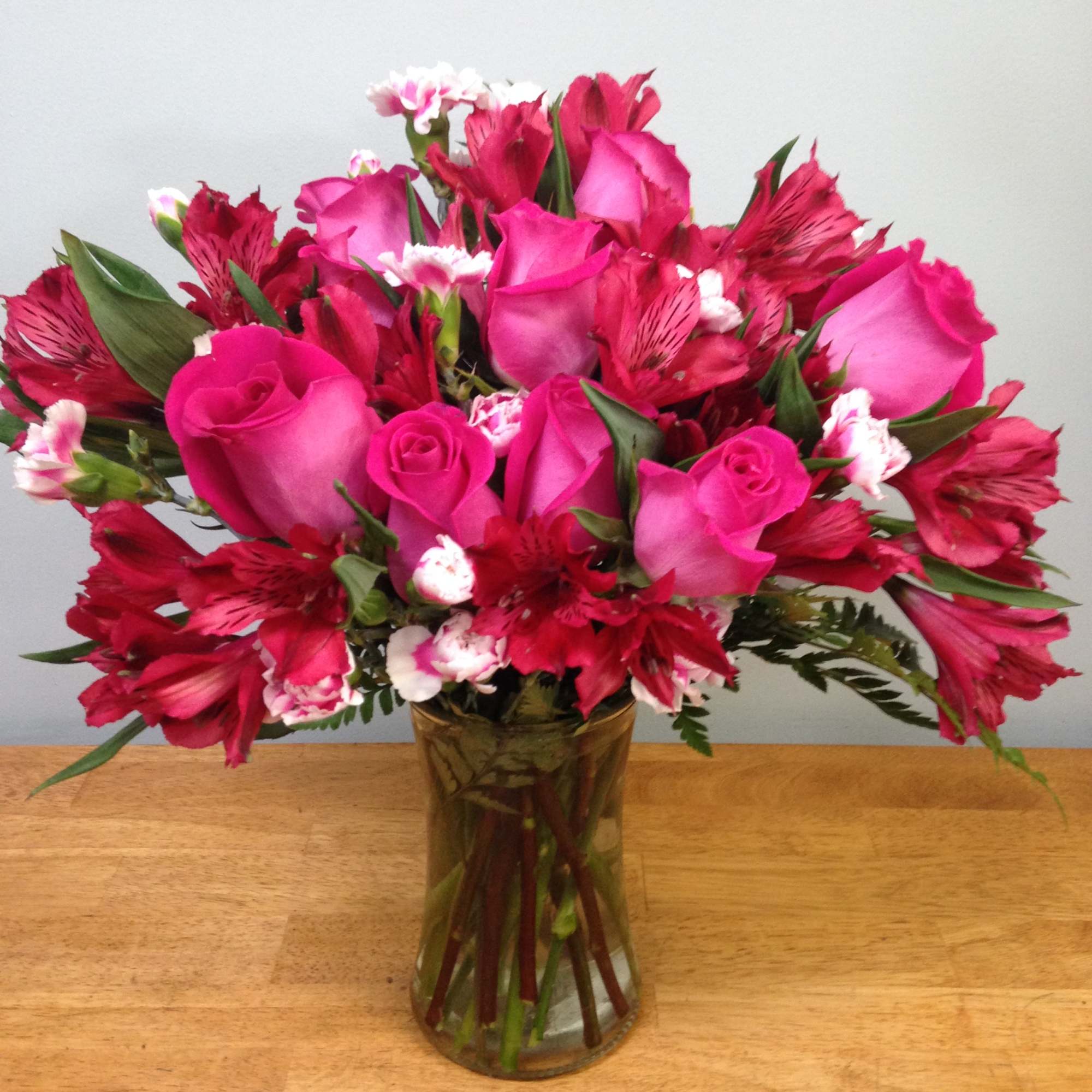 Pink roses and red alstroemeria in a glass vase