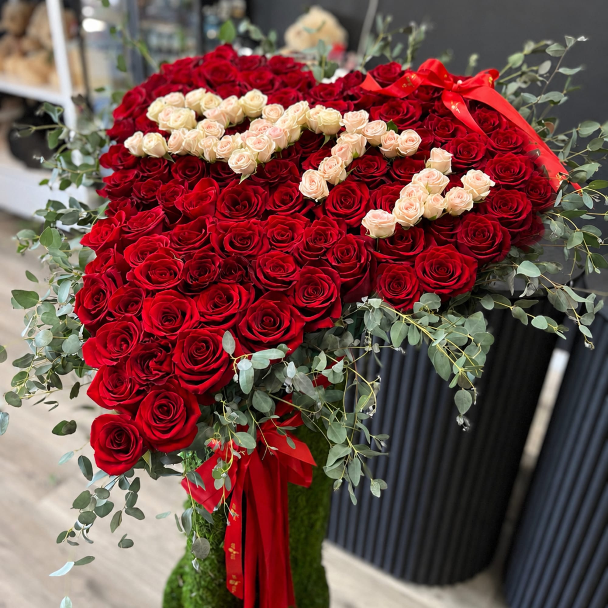 A tall floral stand beautifully arranged with lush greenery and vibrant seasonal, photo 3 of 3