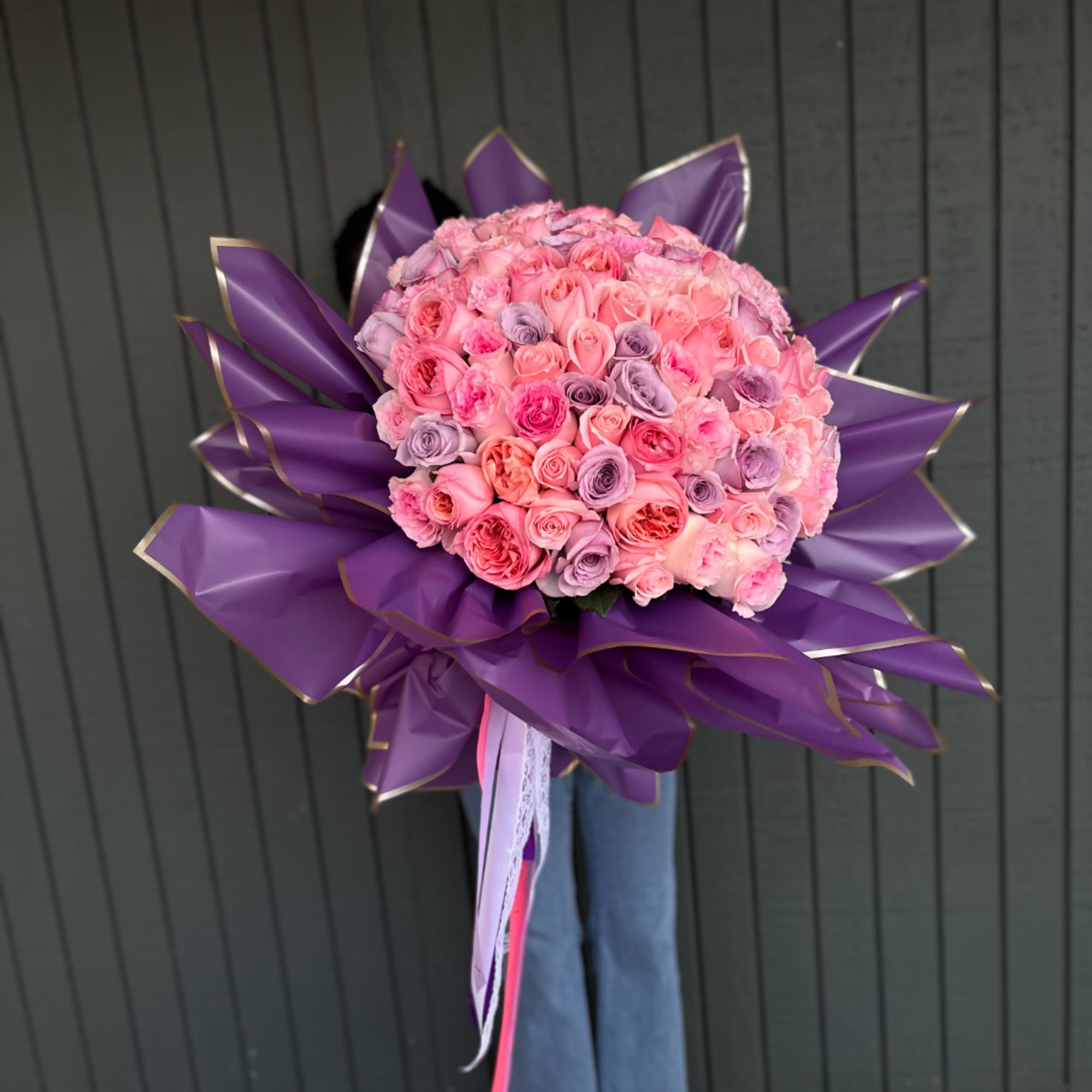 Large bouquet of pink and lavender roses wrapped in purple paper, photo 2 of 3