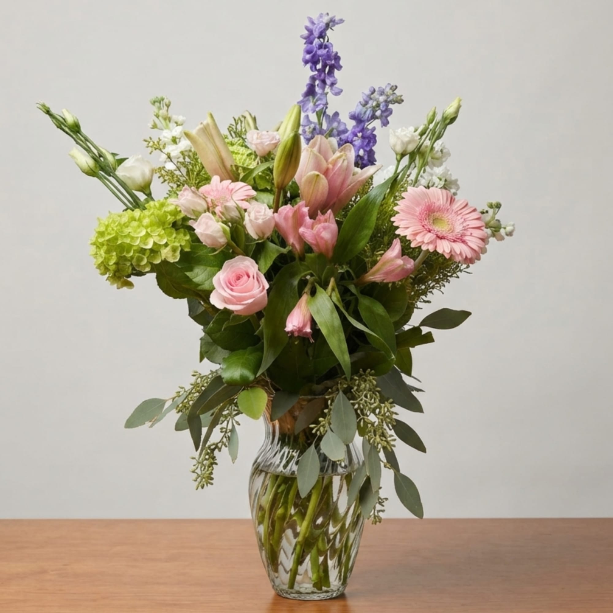 Pink and purple mixed bouquet in a clear glass vase