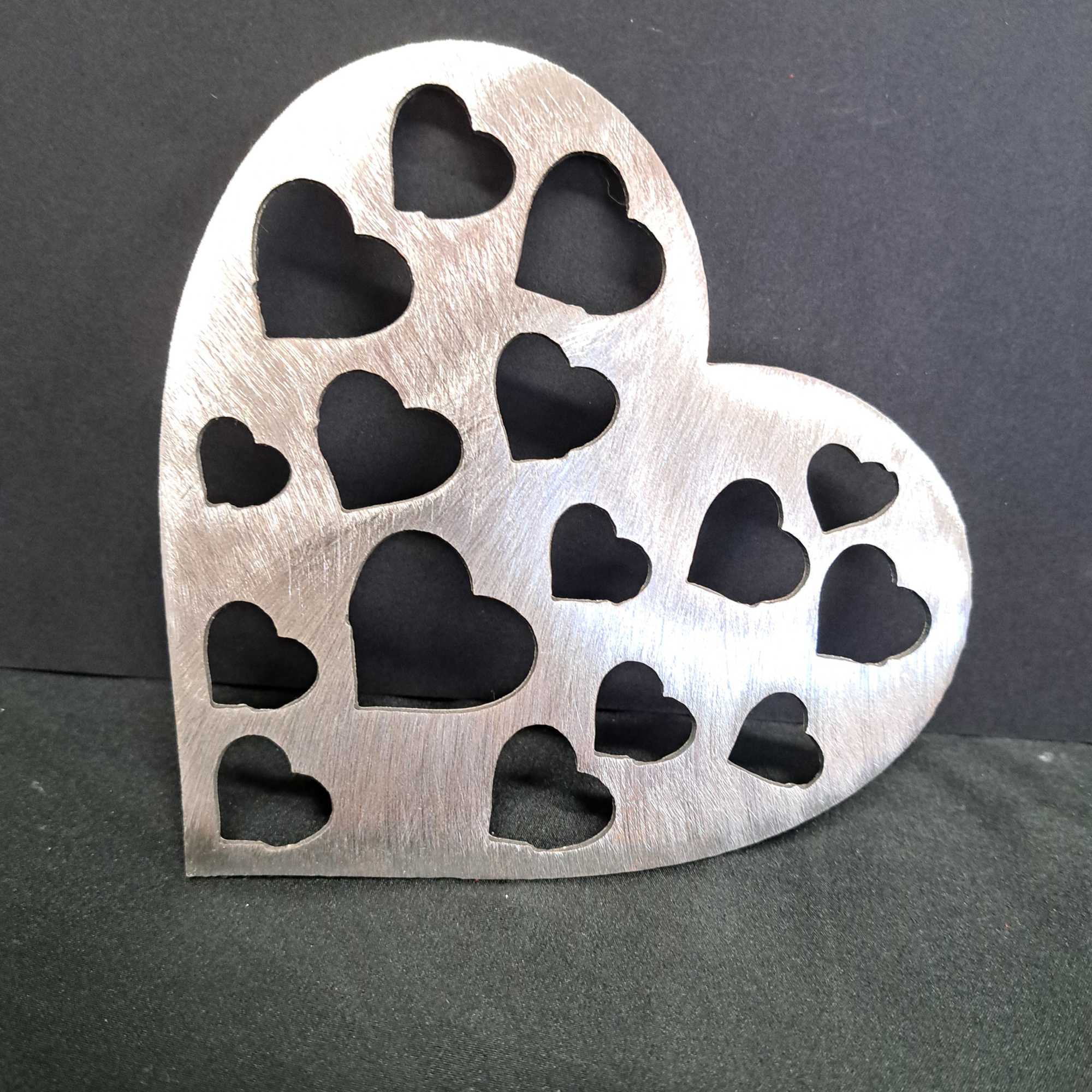 A glossy red heart-shaped metal wall hanger with playful heart cutouts brings, photo 2 of 2
