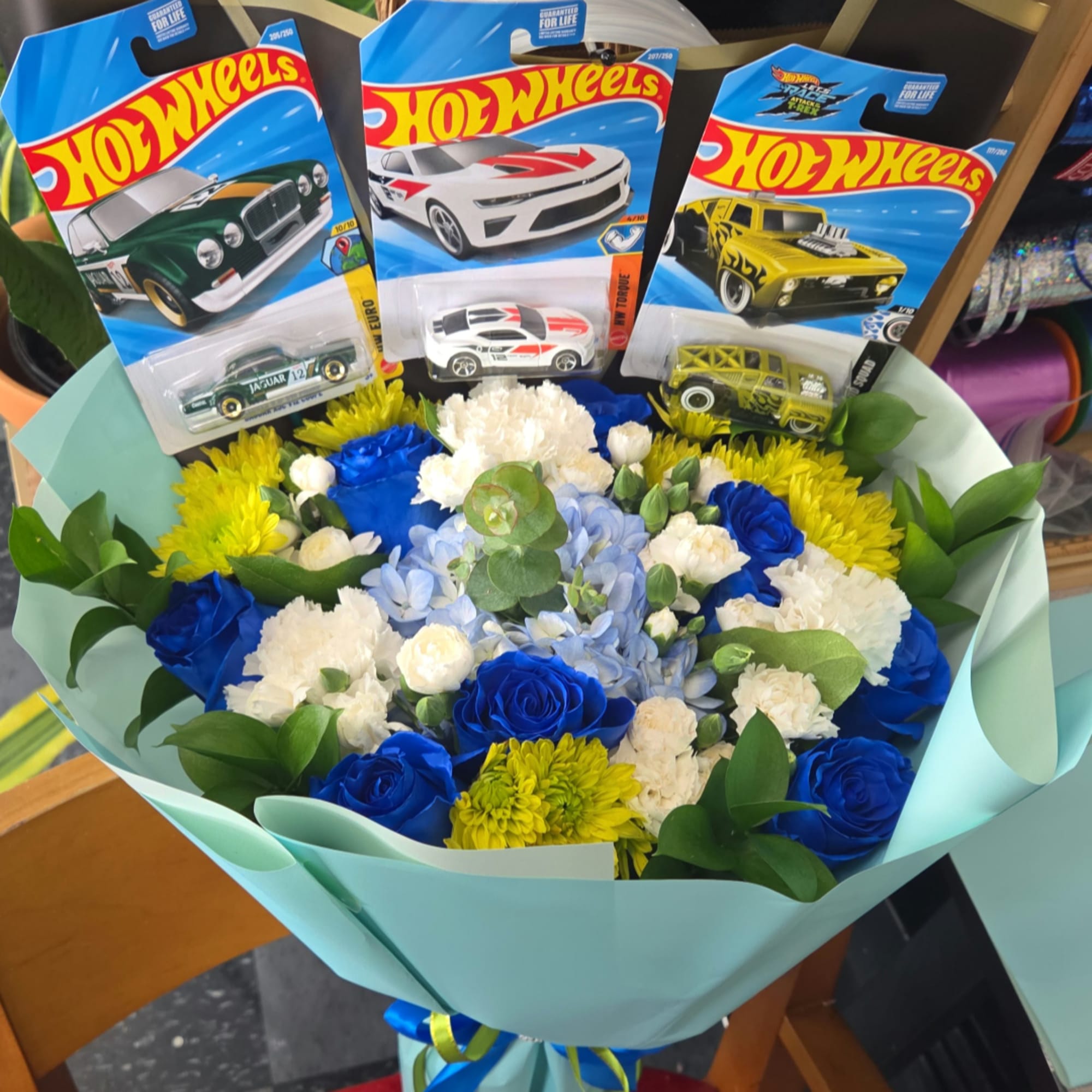 Bouquet of blue, white, and yellow flowers with Hot Wheels toy cars, photo 4 of 4