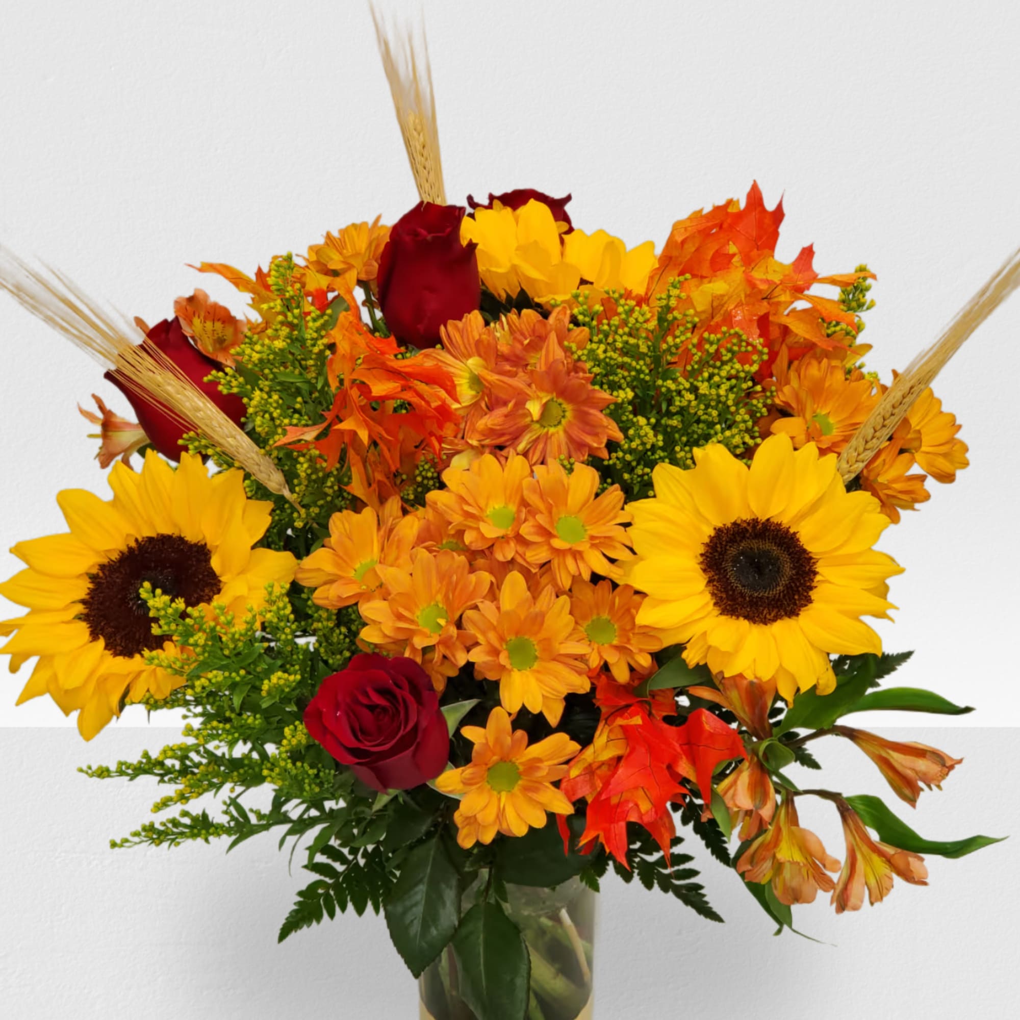 Bouquet of sunflowers, red roses, and orange mums in a vase