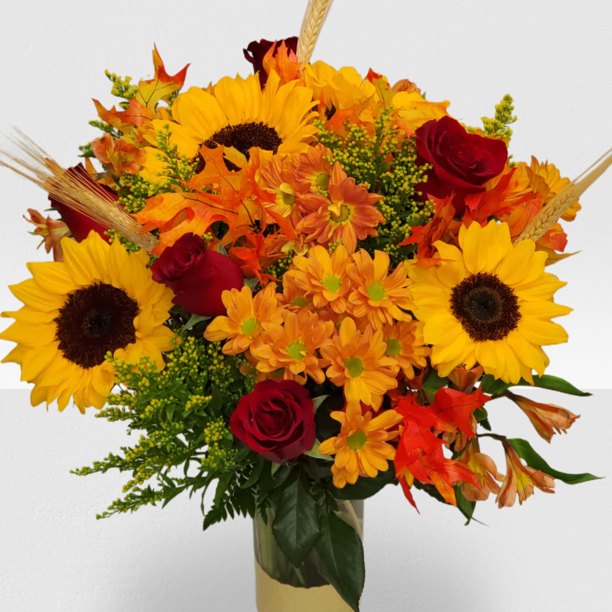 Bouquet of sunflowers, red roses, and orange flowers in a gold vase