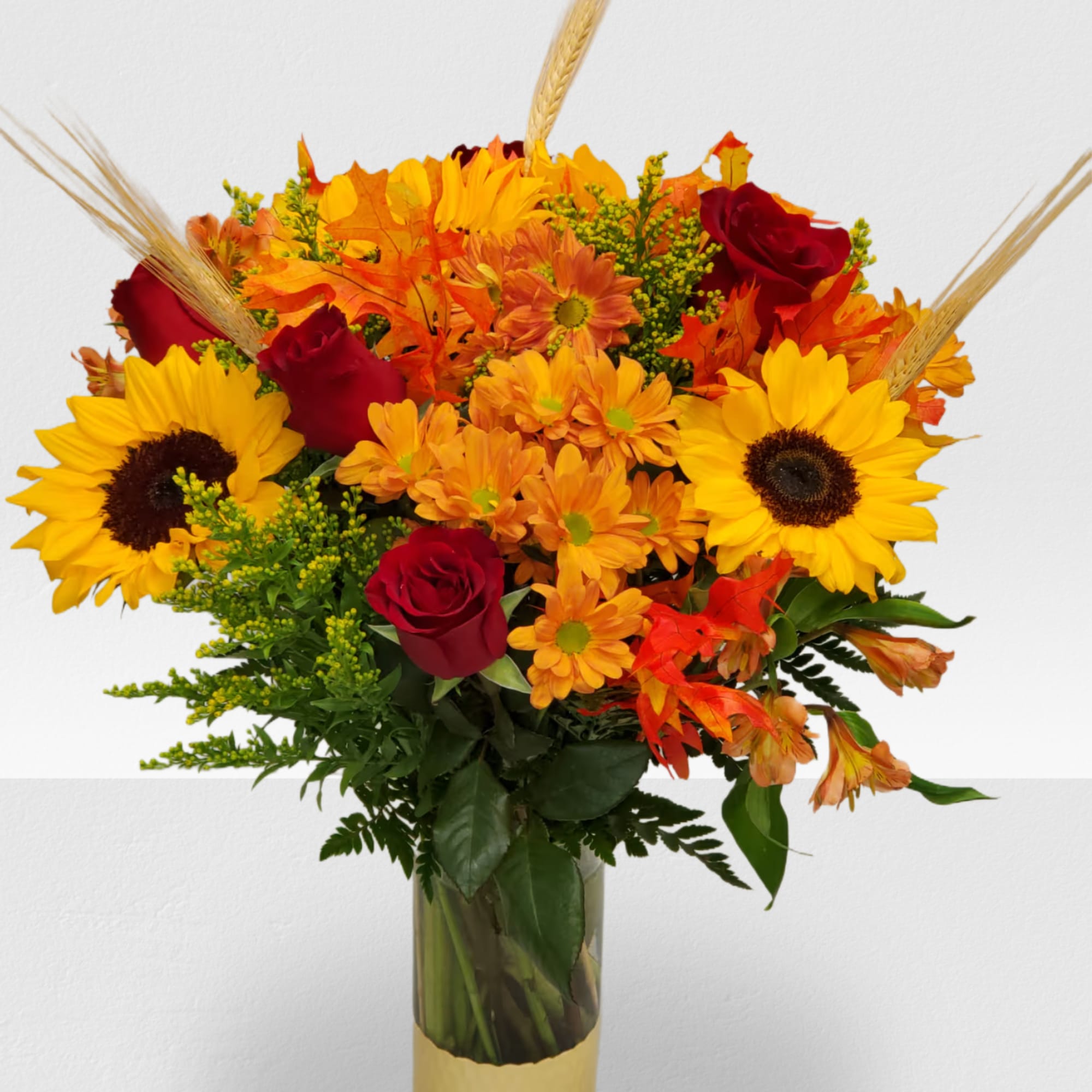 Bouquet of sunflowers, red roses, and orange mums in a gold vase