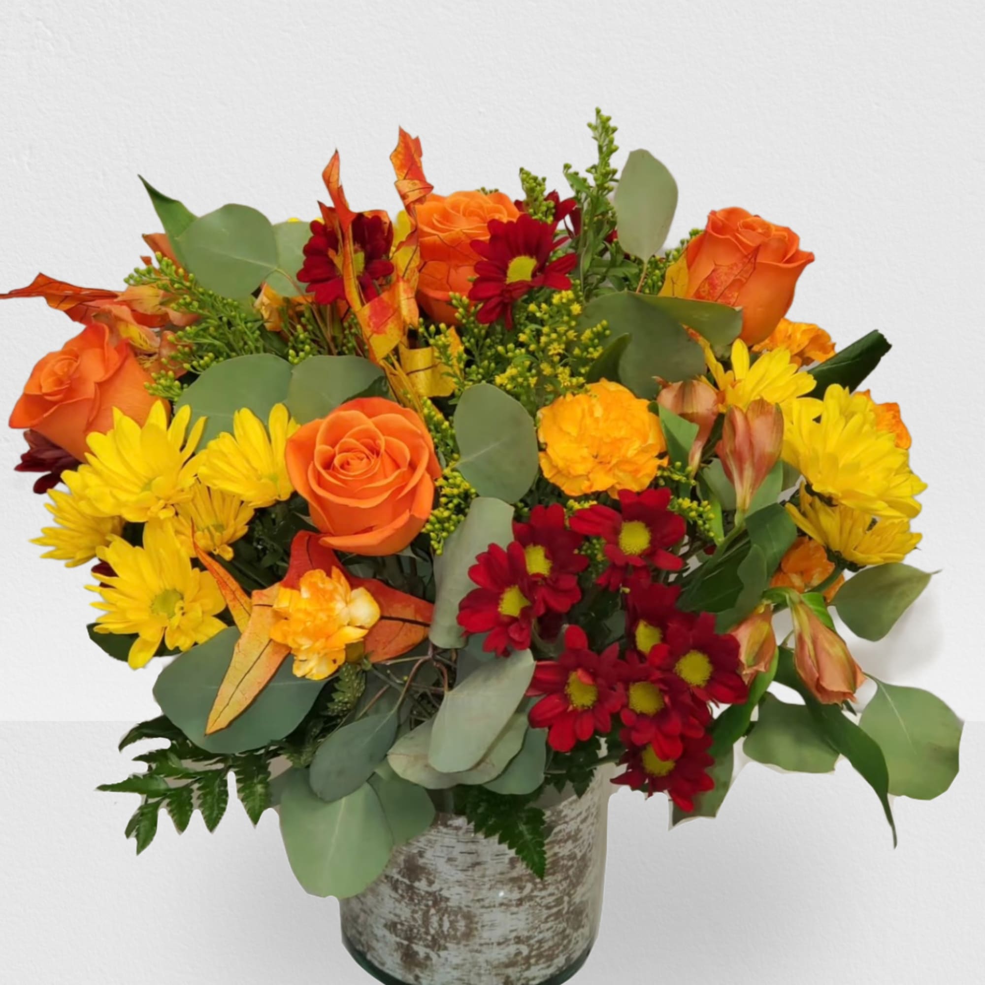 Orange roses and red-yellow daisies in a rustic vase