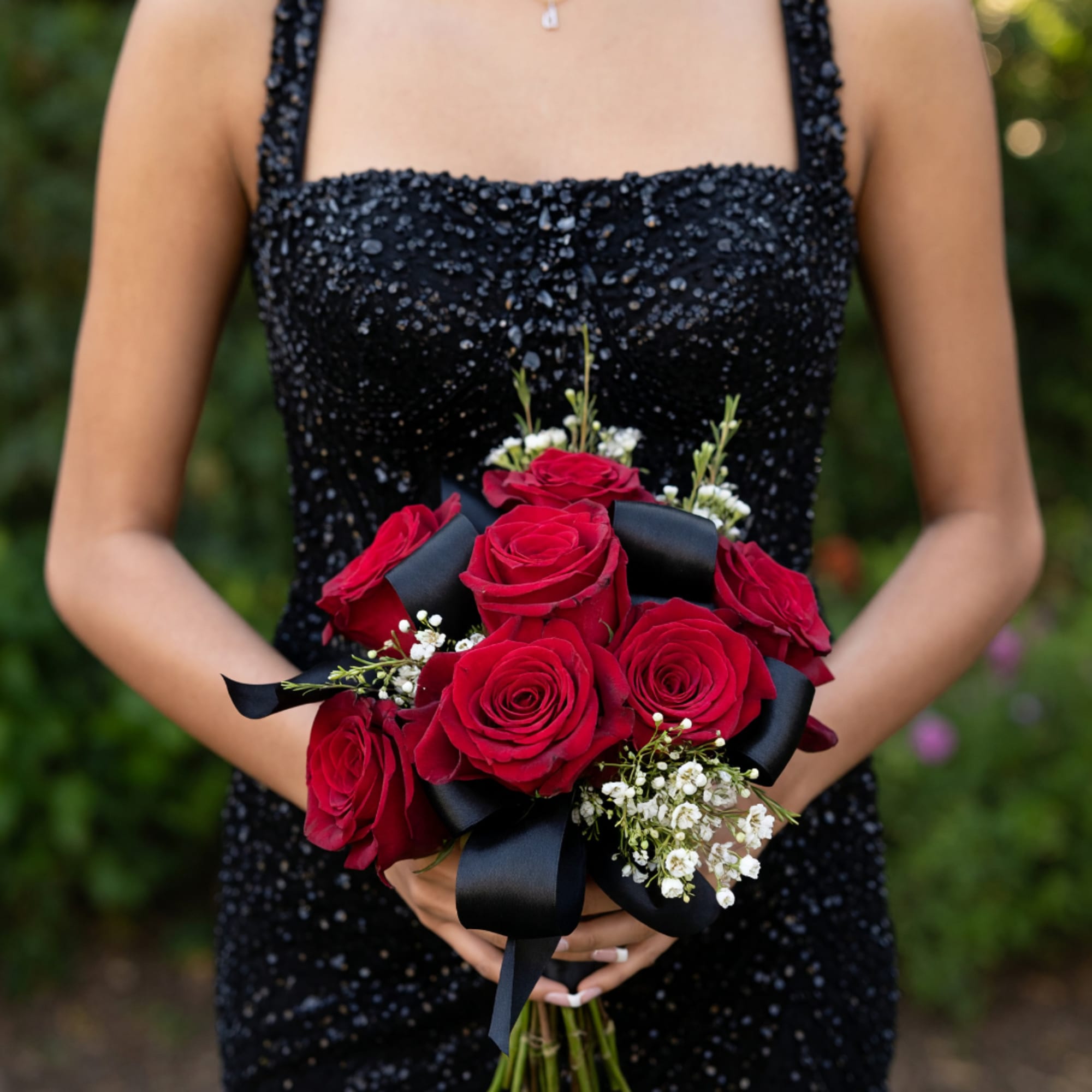Woman holding a bouquet of red roses with black ribbon