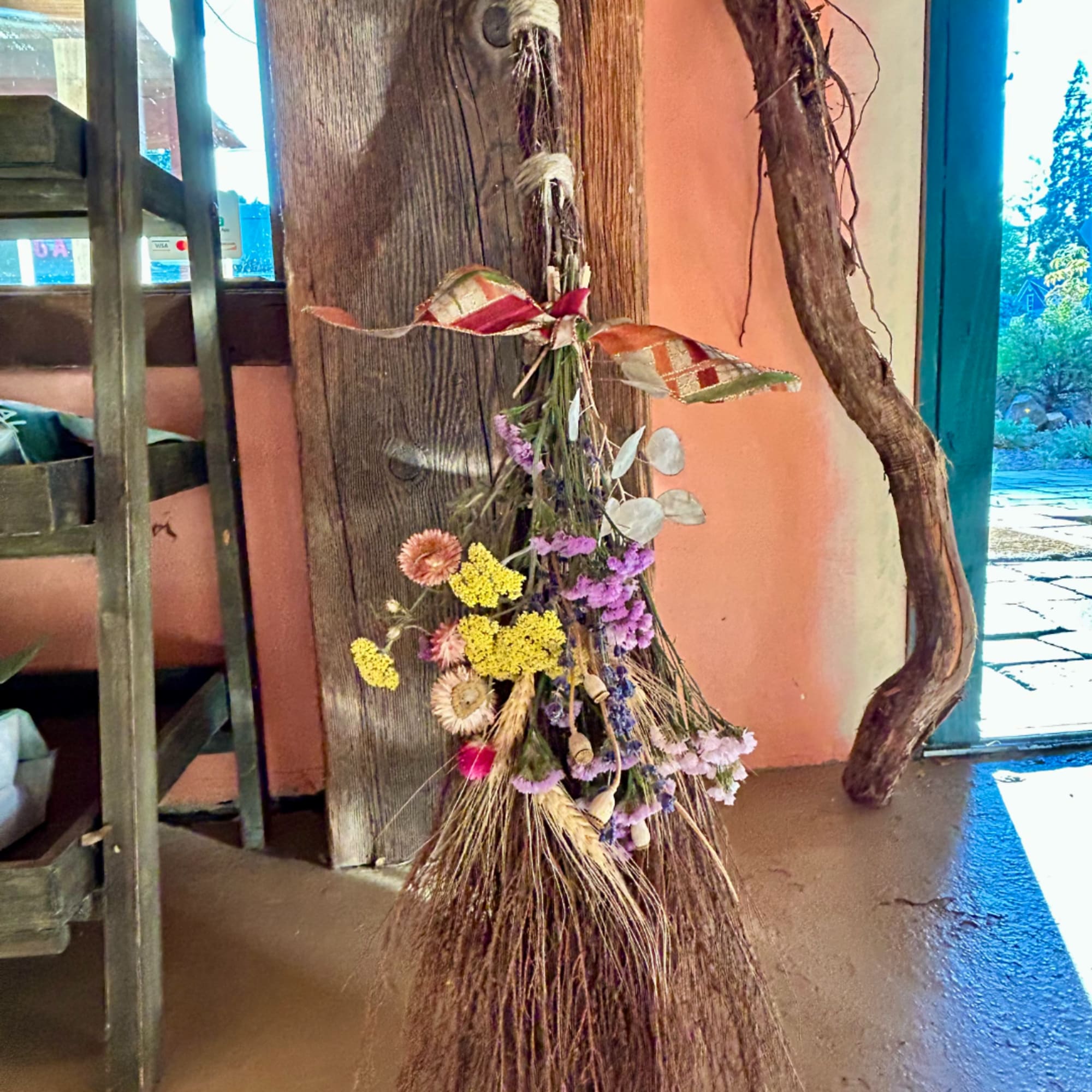 Dried flower bundle tied to a rustic broom handle