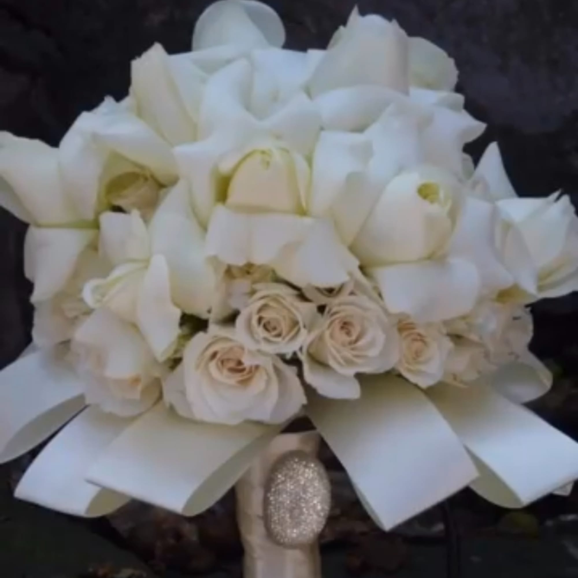 White bouquet with roses and calla lilies tied with a satin ribbon
